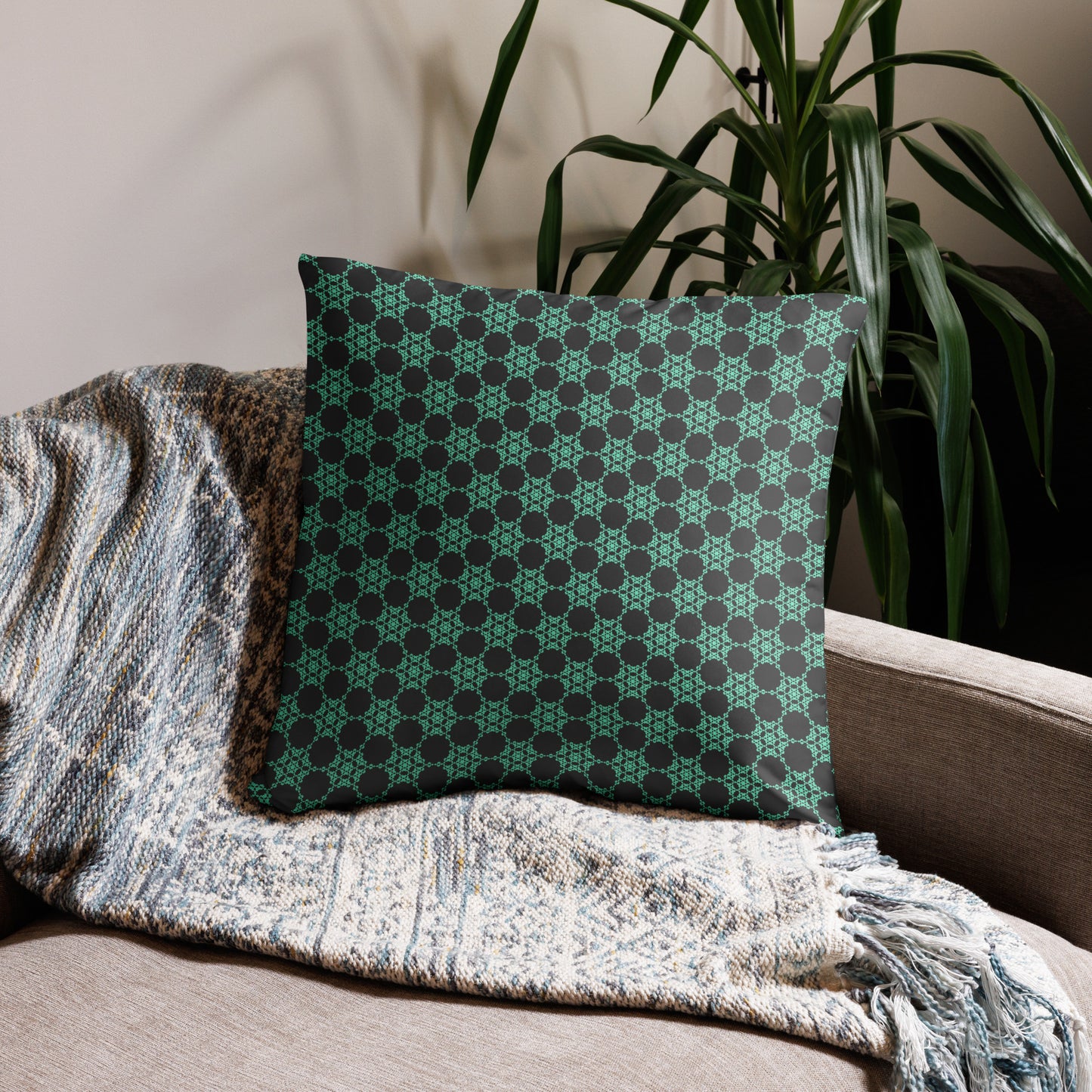 22″×22″ throw pillow with the 'Flowers Victory' charcoal and mint geometric pattern on a couch.