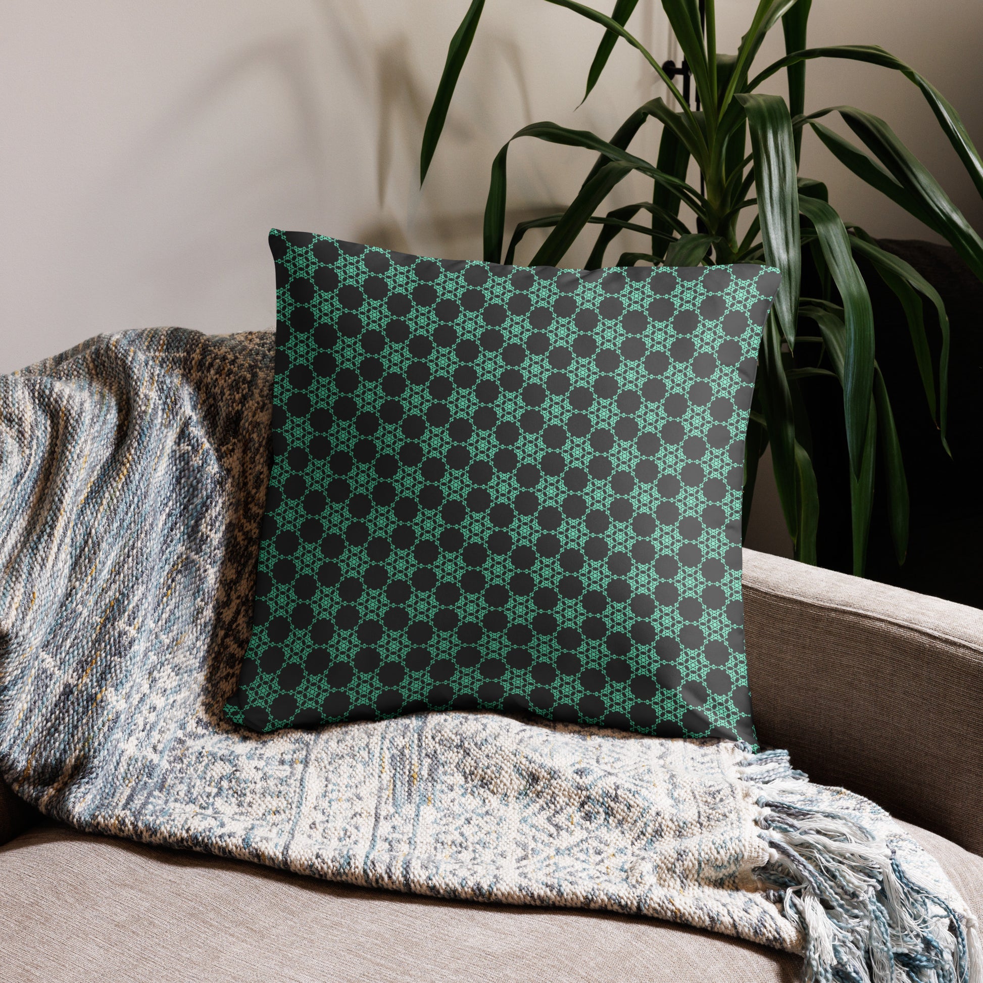 22″×22″ throw pillow with the 'Flowers Victory' charcoal and mint geometric pattern on a couch.