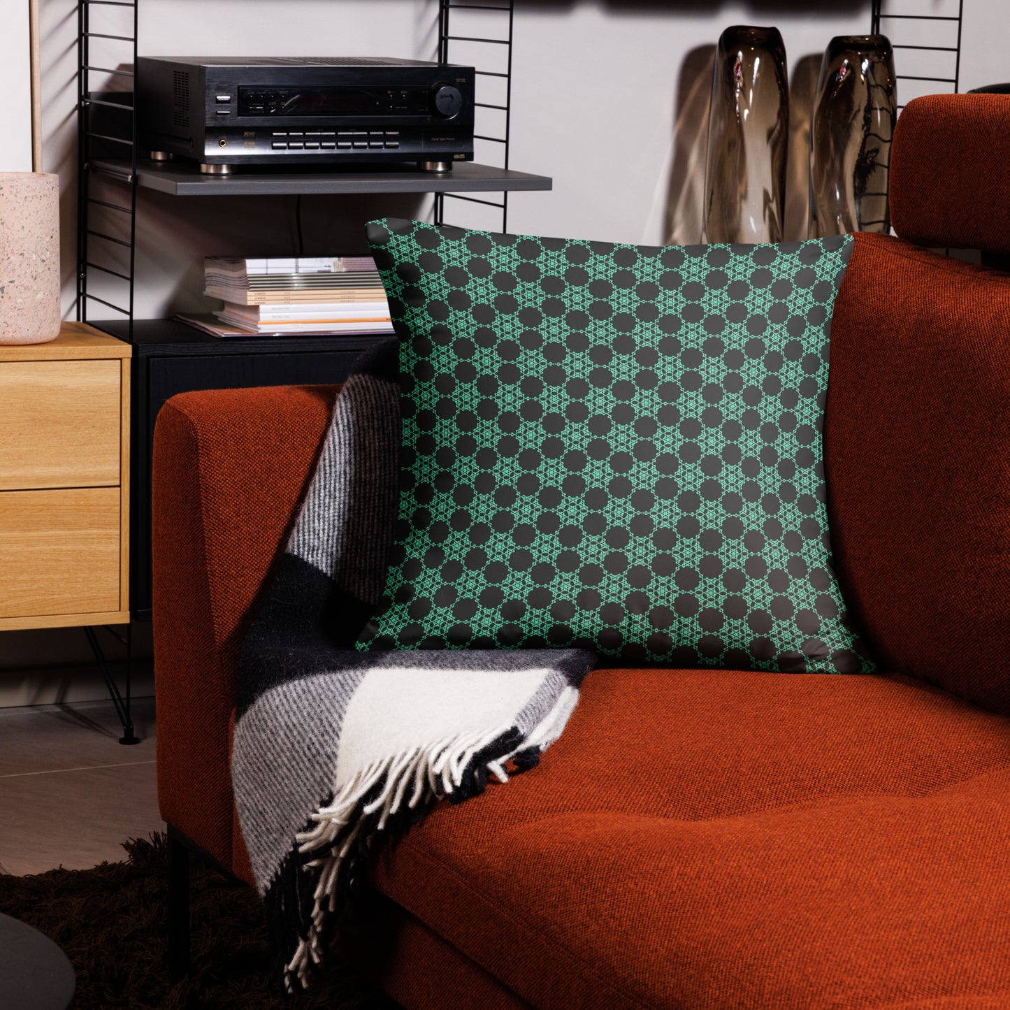22″×22″ throw pillow with the 'Flowers Victory' charcoal and mint geometric pattern on a couch.