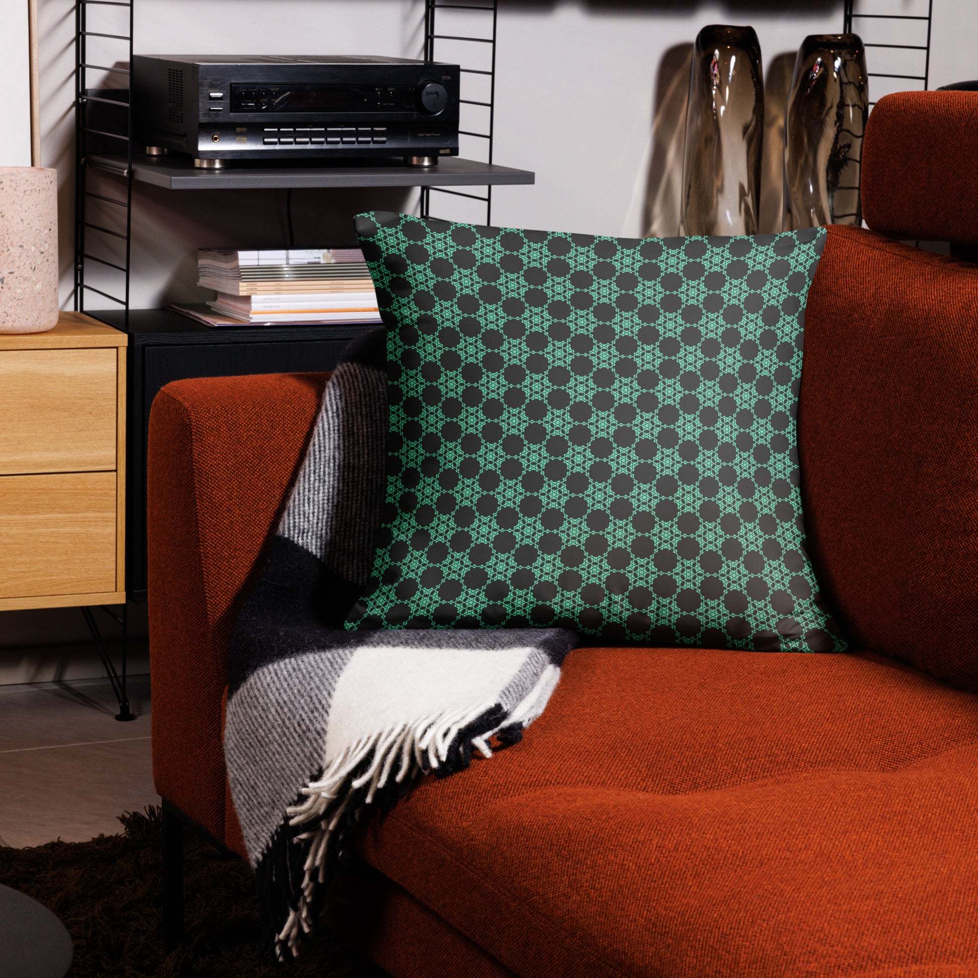 22″×22″ throw pillow with the 'Flowers Victory' charcoal and mint geometric pattern on a couch.