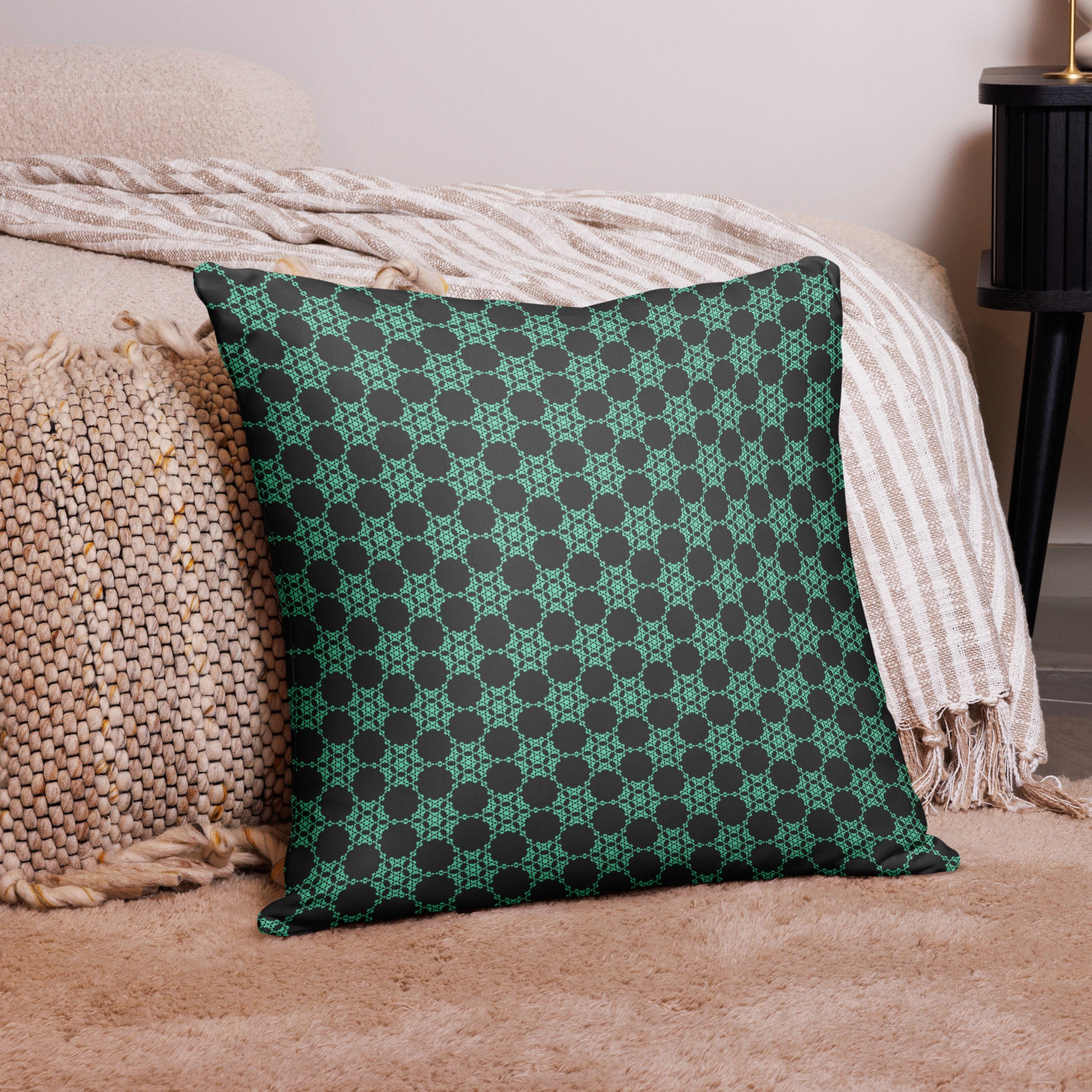 22″×22″ throw pillow with the 'Flowers Victory' charcoal and mint geometric pattern on a couch.