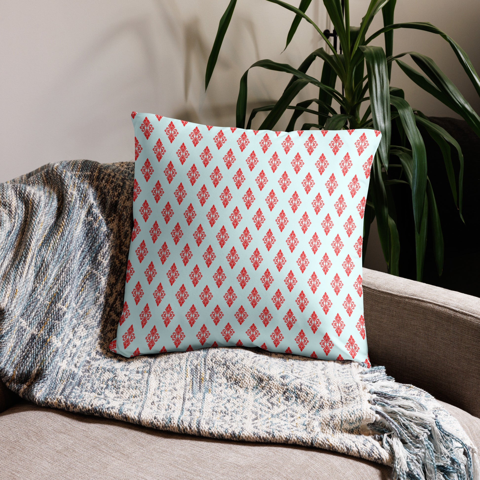22″×22″ throw pillow with the 'Digon' sky blue and red geometric pattern on a couch.