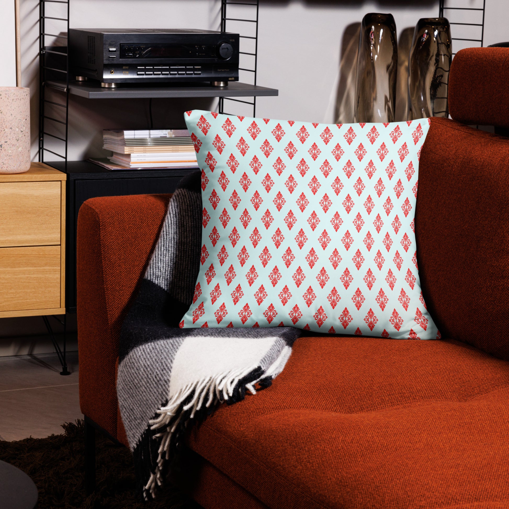 22″×22″ throw pillow with the 'Digon' sky blue and red geometric pattern on a couch.