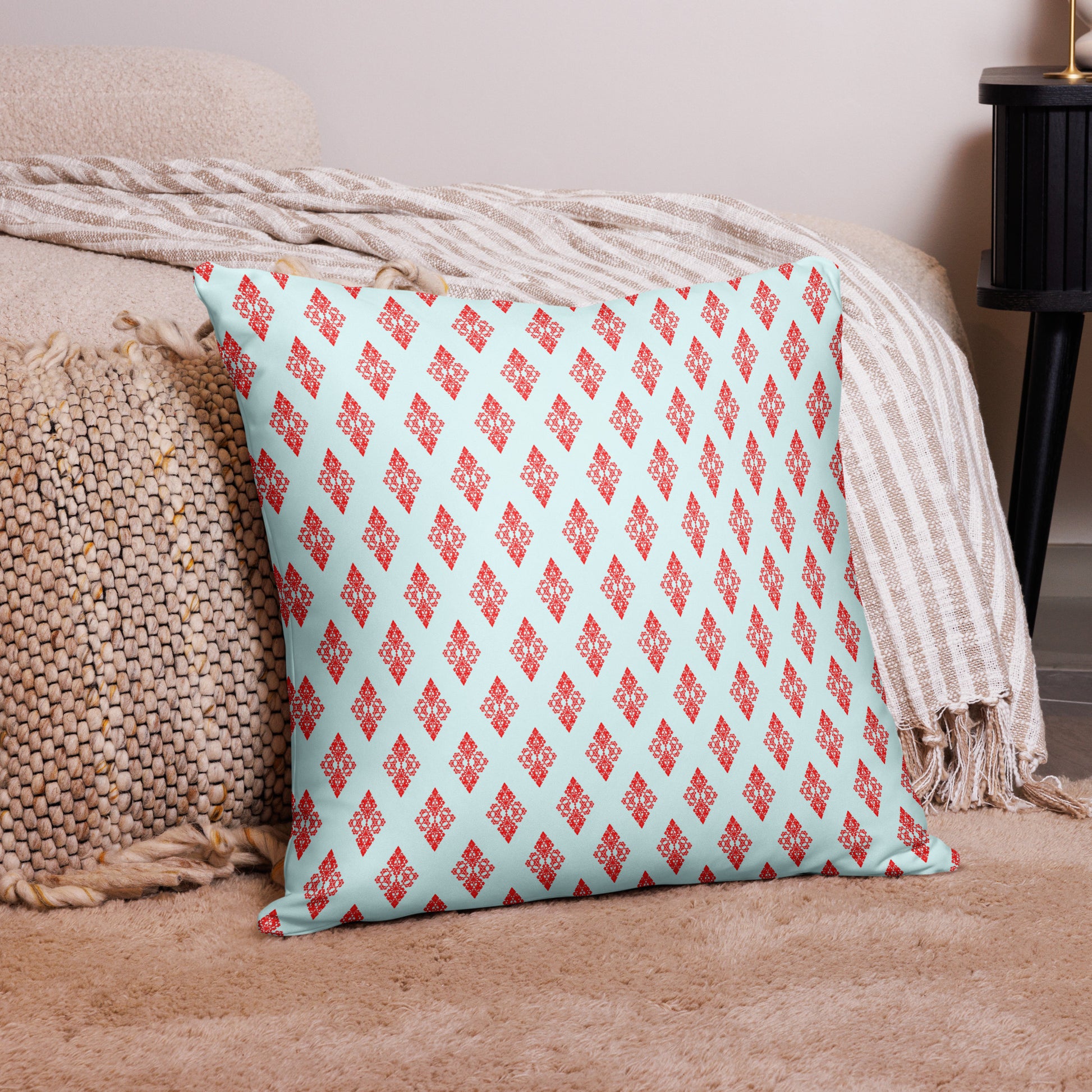22″×22″ throw pillow with the 'Digon' sky blue and red geometric pattern on a couch.