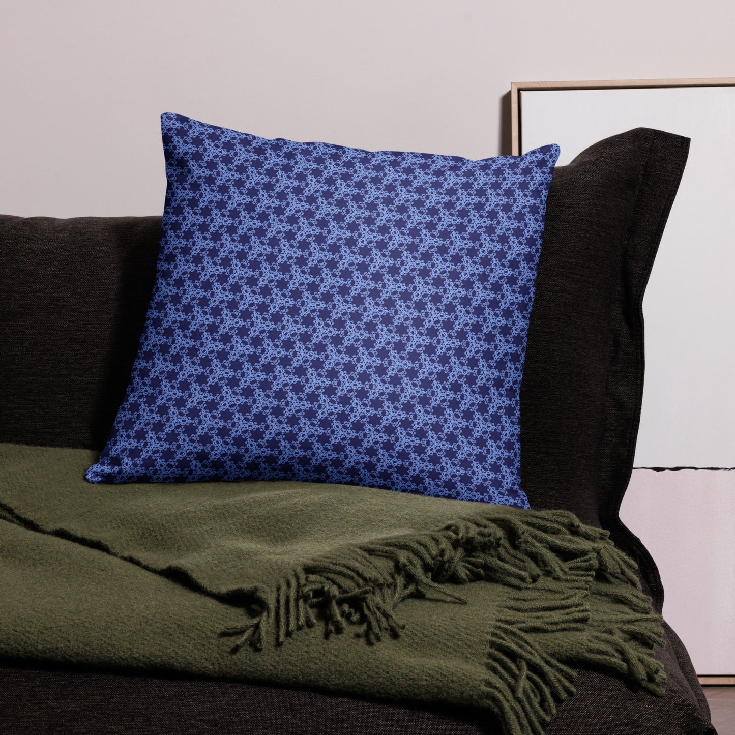 22″×22″ throw pillow with the 'Trigon' navy and blue geometric pattern on a couch.