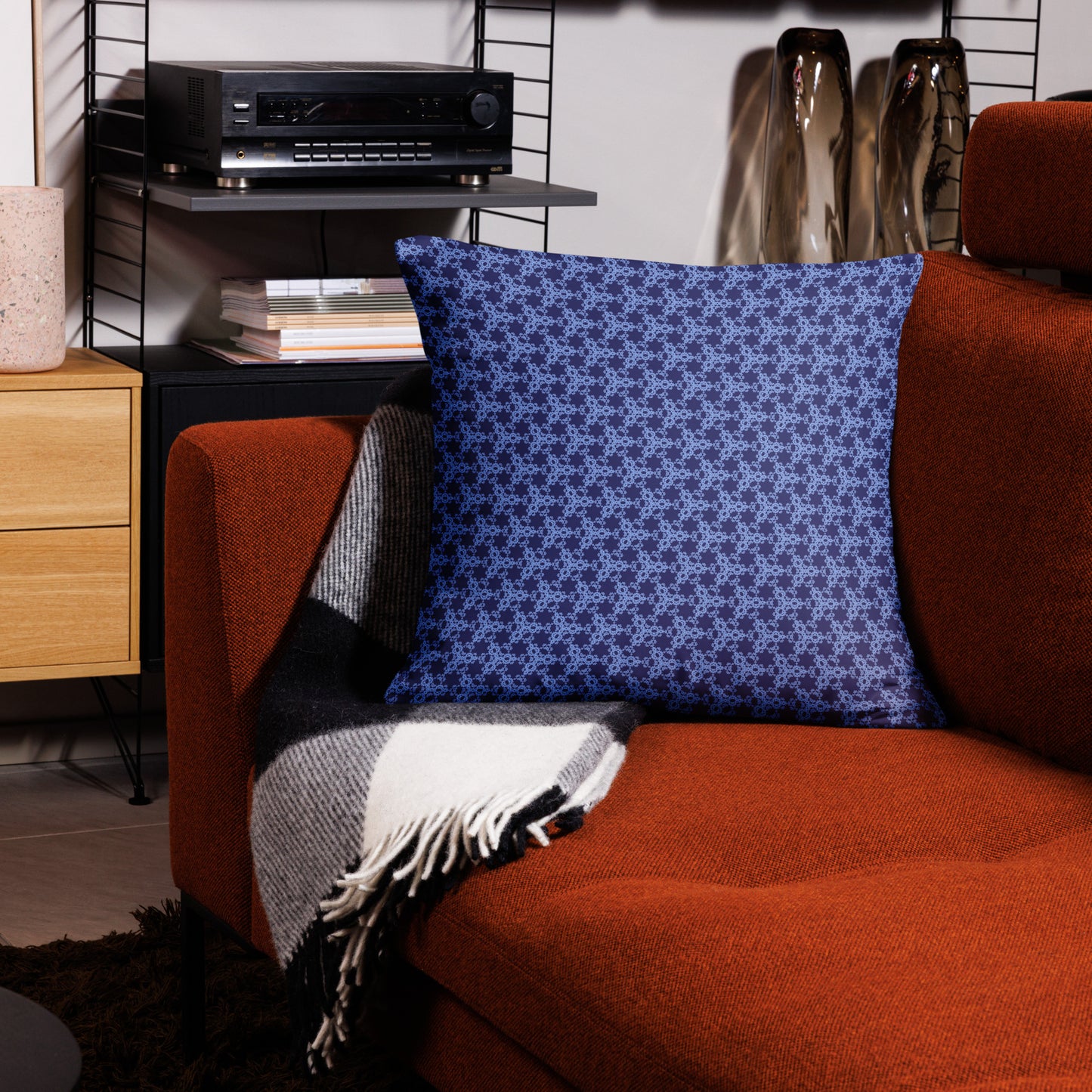 22″×22″ throw pillow with the 'Trigon' navy and blue geometric pattern on a couch.
