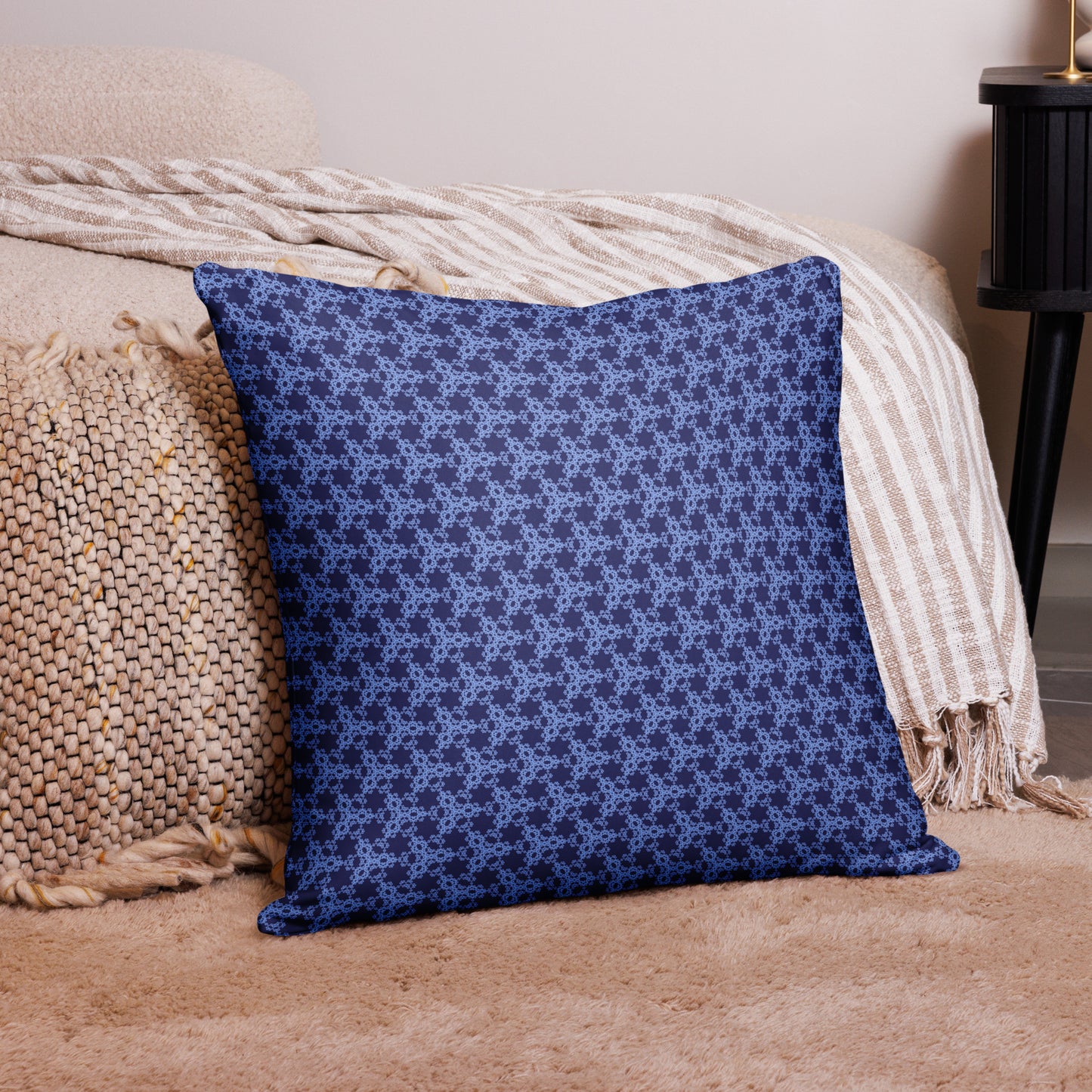 22″×22″ throw pillow with the 'Triagon' navy and blue geometric pattern on a couch.