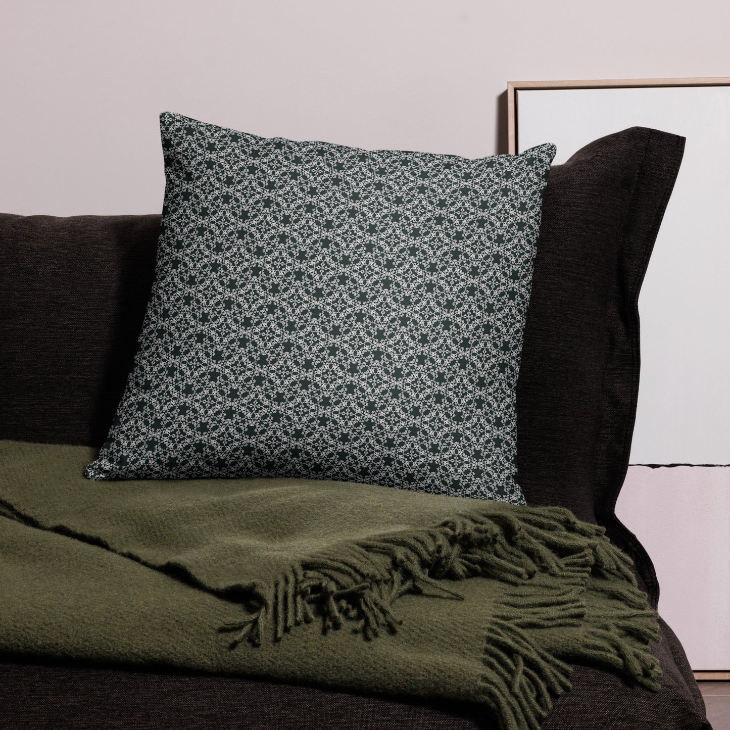 22″×22″ throw pillow with the 'Tetragon' charcoal and white geometric pattern on a couch.