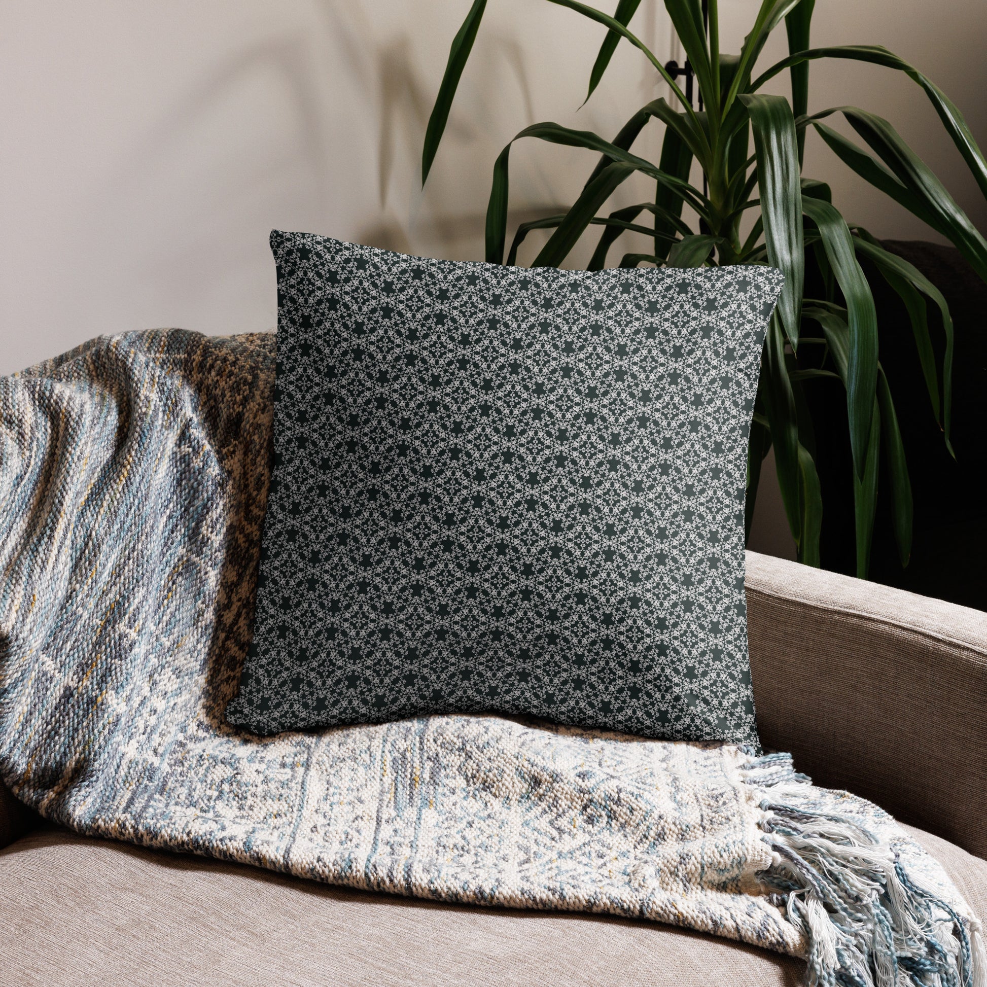 22″×22″ throw pillow with the 'Tetragon' charcoal and white geometric pattern on a couch.