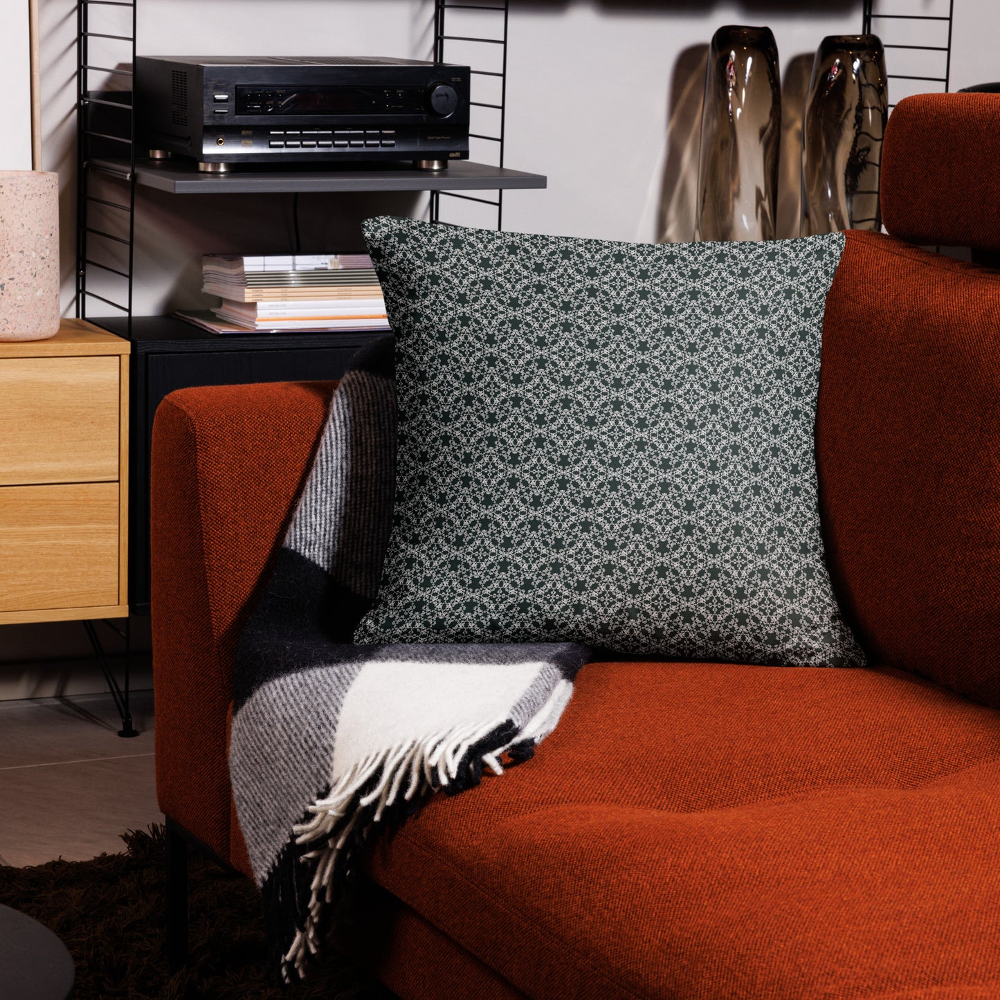 22″×22″ throw pillow with the 'Tetragon' charcoal and white geometric pattern on a couch.