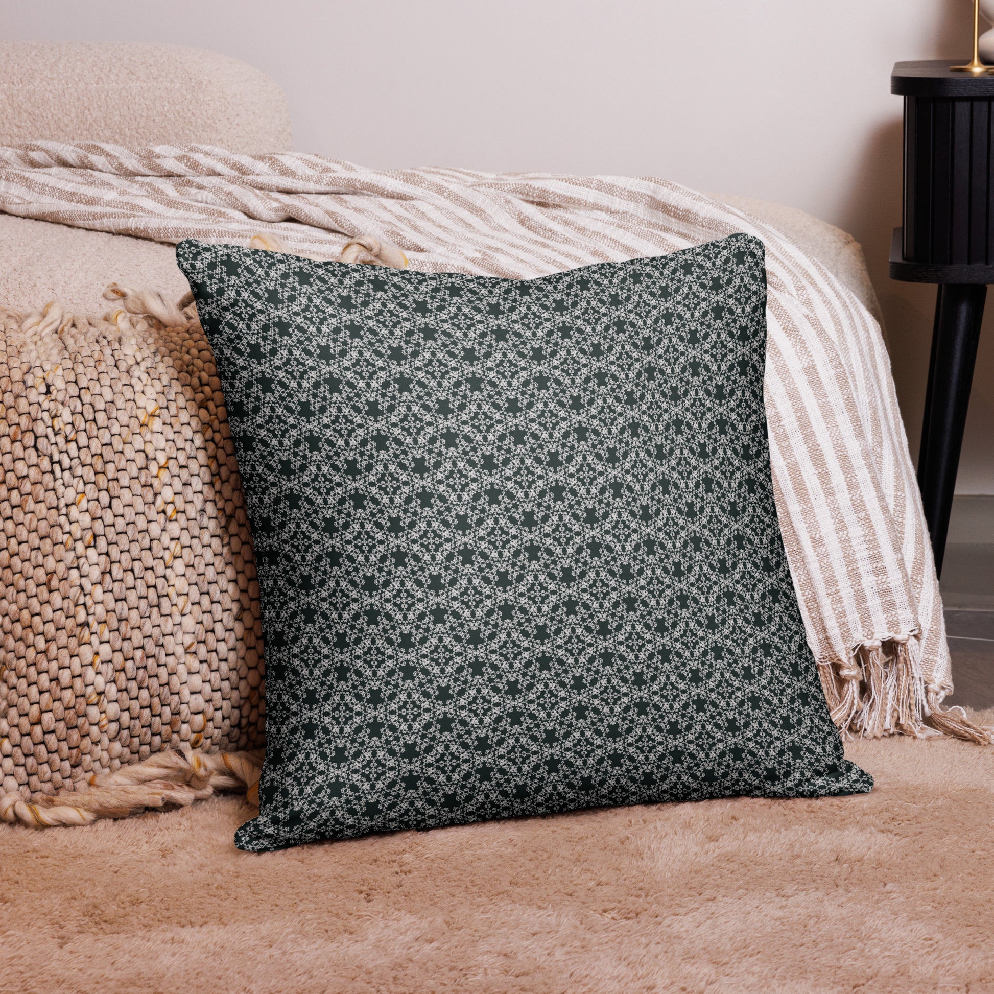 22″×22″ throw pillow with the 'Tetragon' charcoal and white geometric pattern on a couch.