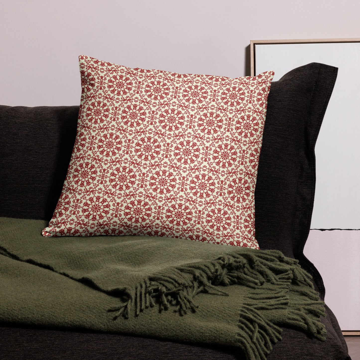 22″×22″ throw pillow with the ‘Decagon’ terracotta and beige geometric pattern on a black sofa with an olive throw.