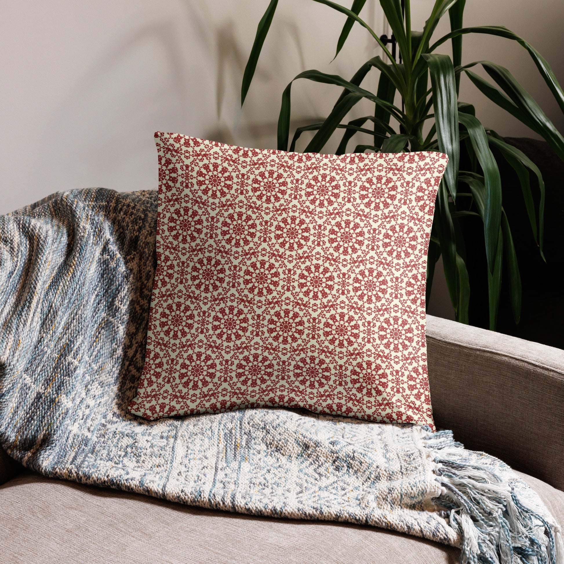 22″×22″ throw pillow with the ‘Decagon’ terracotta and beige geometric pattern on a beige sofa with a woven throw.