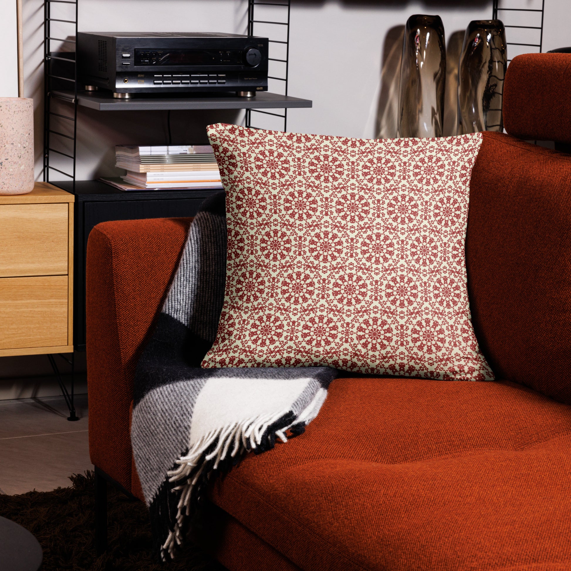 22″×22″ throw pillow with the ‘Decagon’ terracotta and beige geometric pattern on a terracotta sofa with a black and white throw.