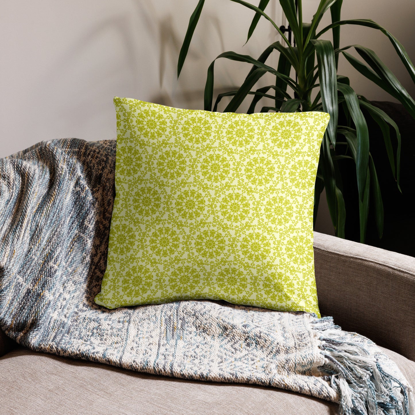22″×22″ throw pillow with the 'Hendecagon' yellow-green geometric pattern on a beige sofa with woven throw
