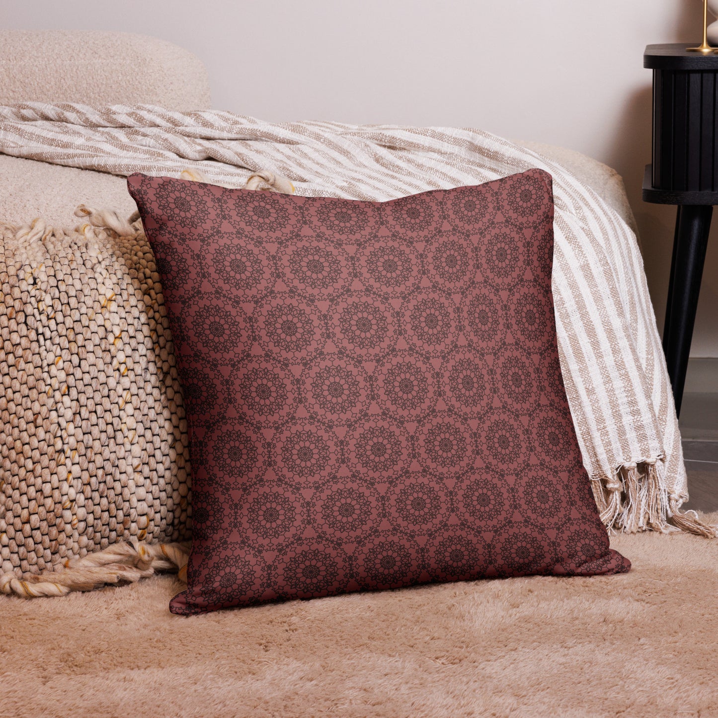 22″×22″ throw pillow with the 'Dodecagon' rose geometric pattern on carpet beside bed with striped throw.