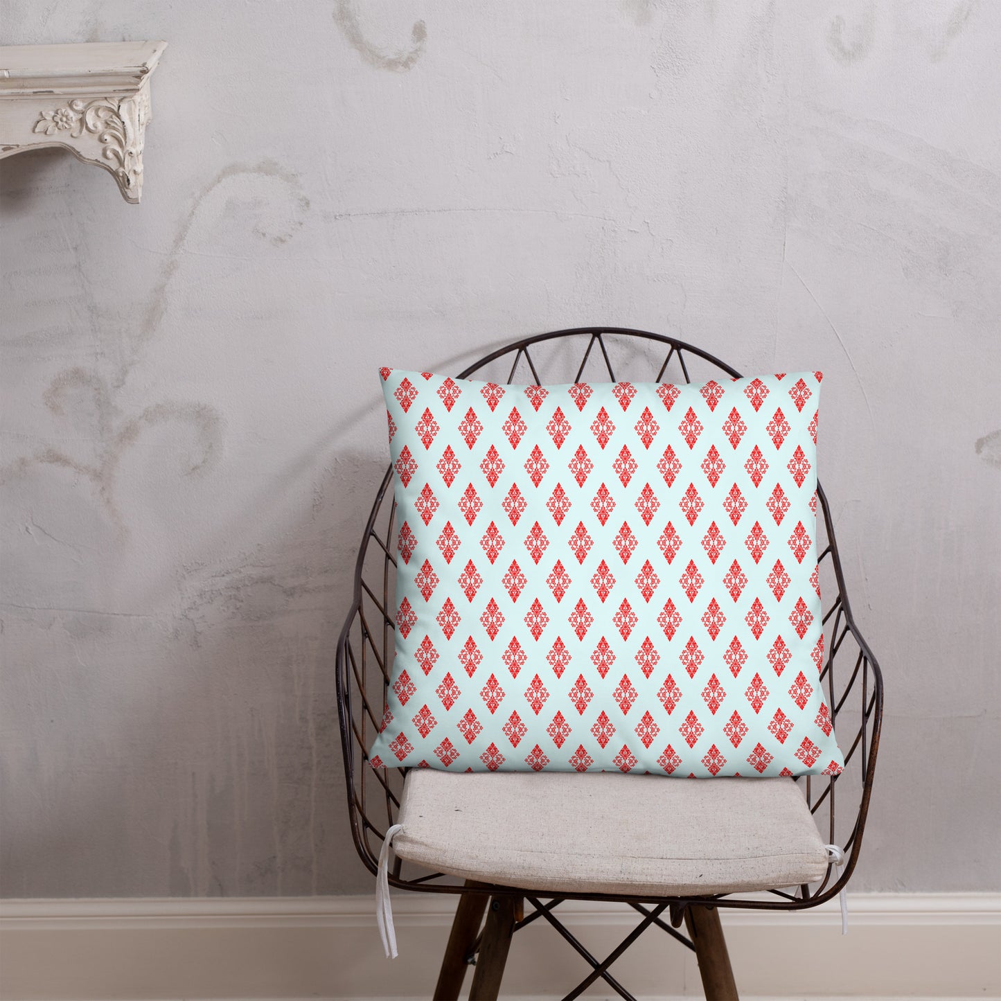 22″×22″ throw pillow with the 'Digon' sky blue and red geometric pattern on a chair.