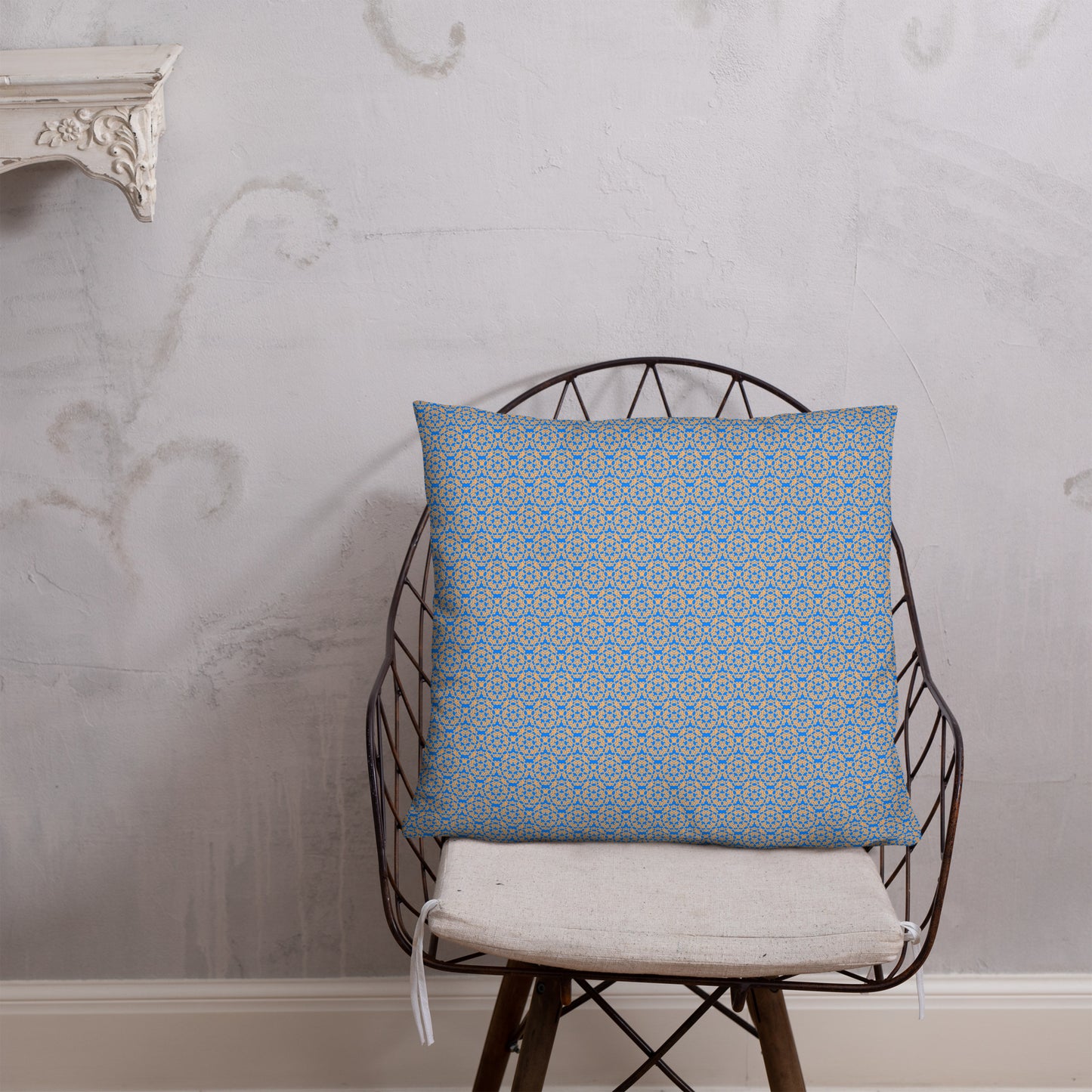 22″×22″ throw pillow with the 'Pentagon' blue and yellow geometric pattern on a chair.