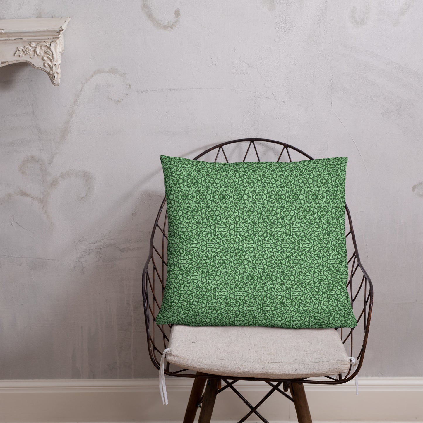 22″×22″ throw pillow with the 'Heptagon' green geometric pattern on a chair.