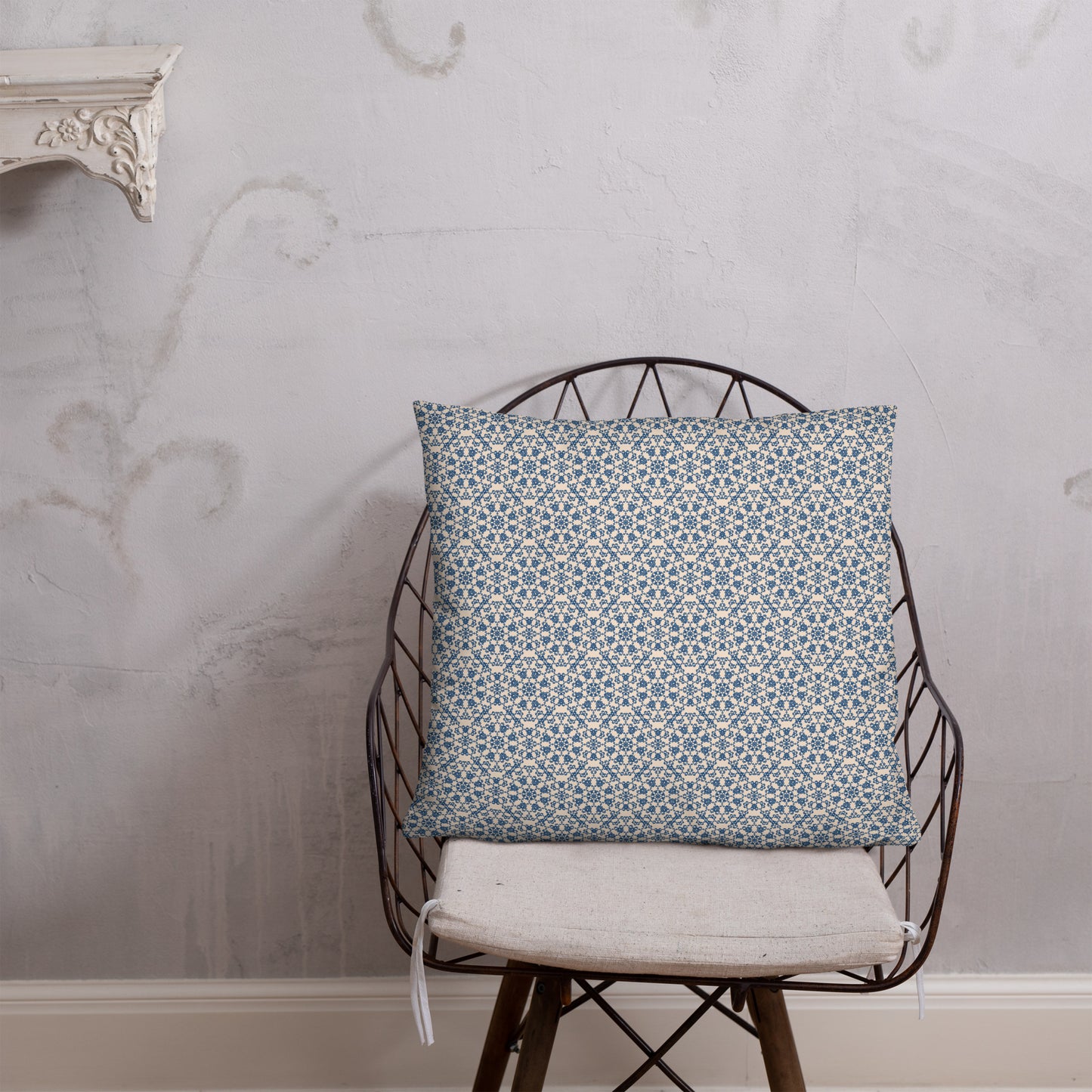 22″×22″ throw pillow with the ‘Octagon’ navy and beige geometric pattern on a wire chair.