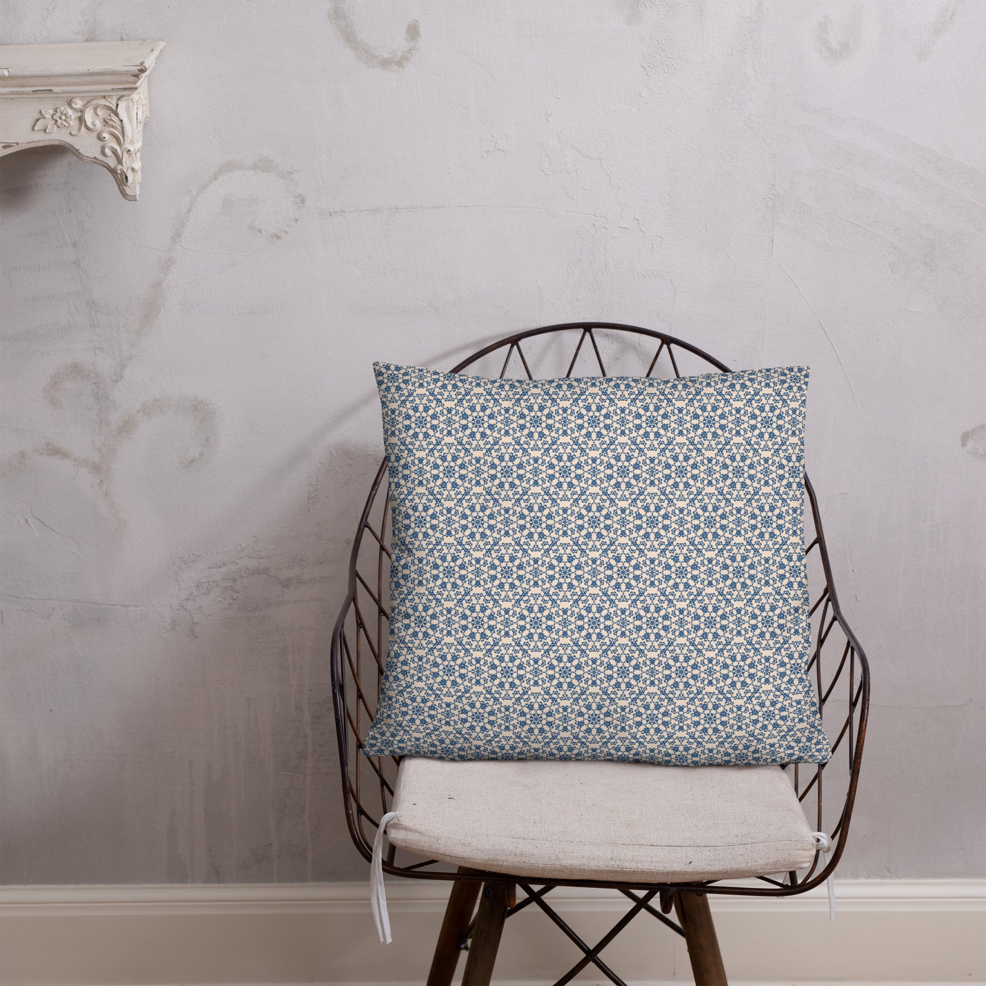22″×22″ throw pillow with the ‘Octagon’ navy and beige geometric pattern on a wire chair.