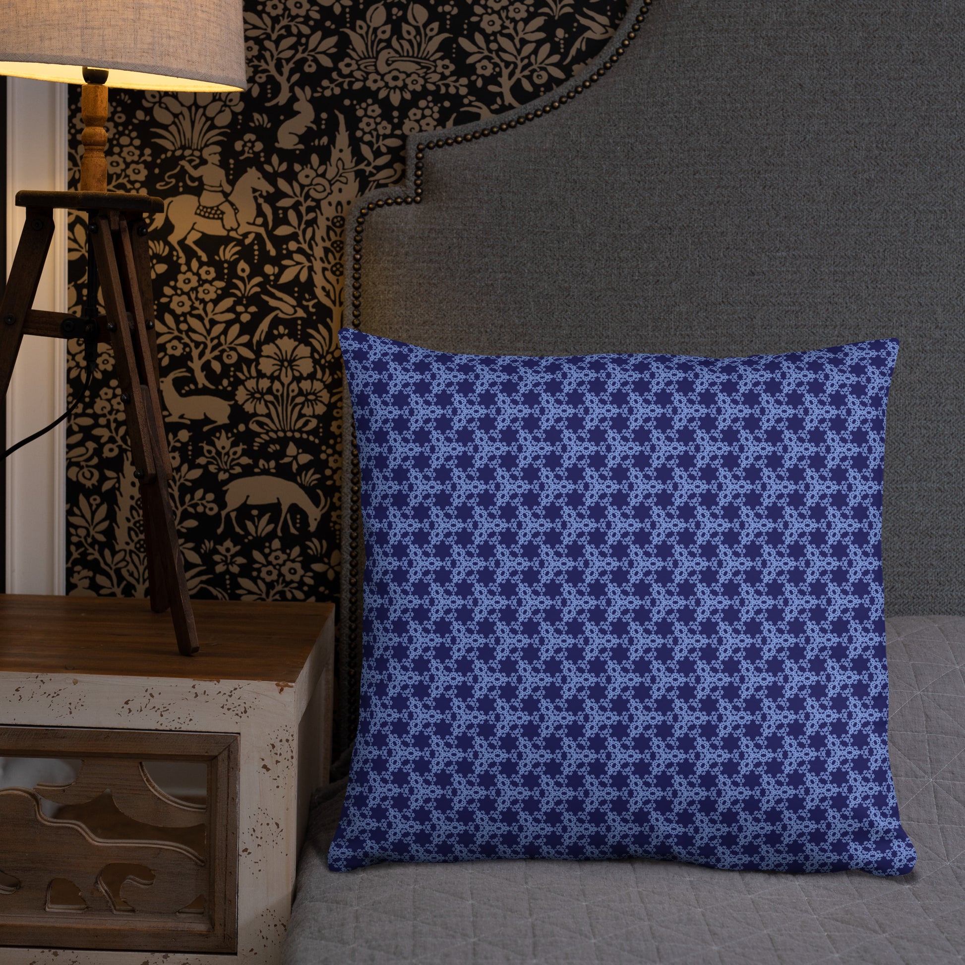 22″×22″ throw pillow with the 'Triagon' navy and blue geometric pattern on a bed.