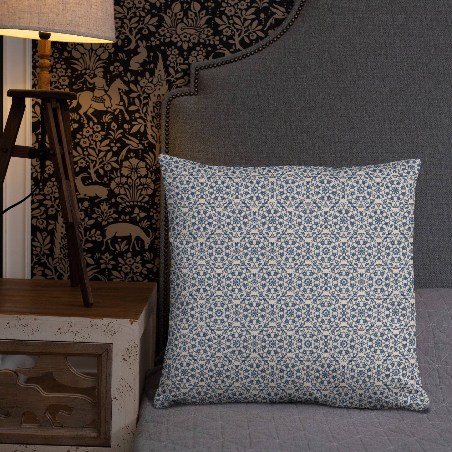 22″×22″ throw pillow with the ‘Octagon’ navy and beige geometric pattern on a bed with upholstered headboard.