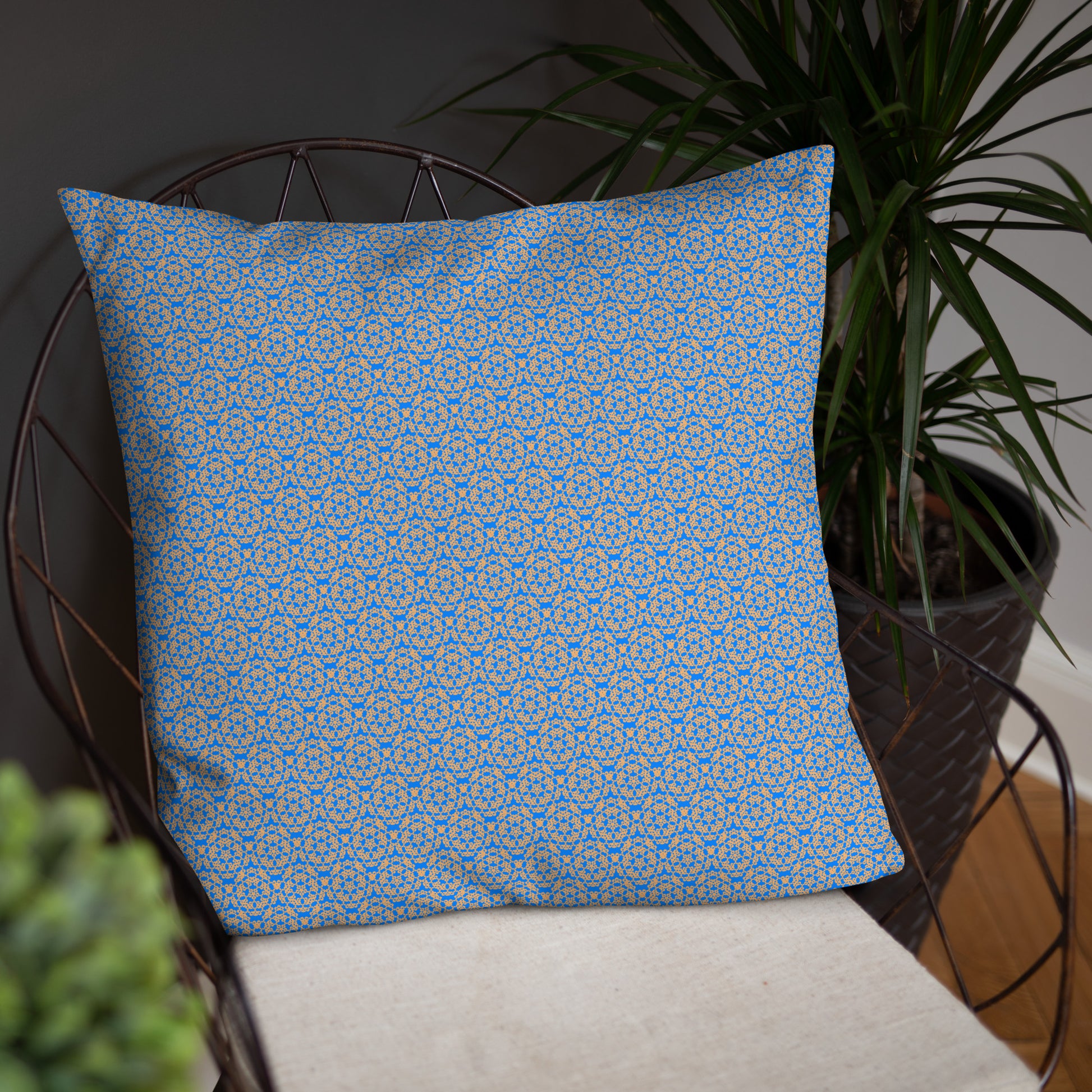 Front of the 22″×22″ basic pillow with the 'Pentagon' blue and yellow fractal geometric pattern on a chair.