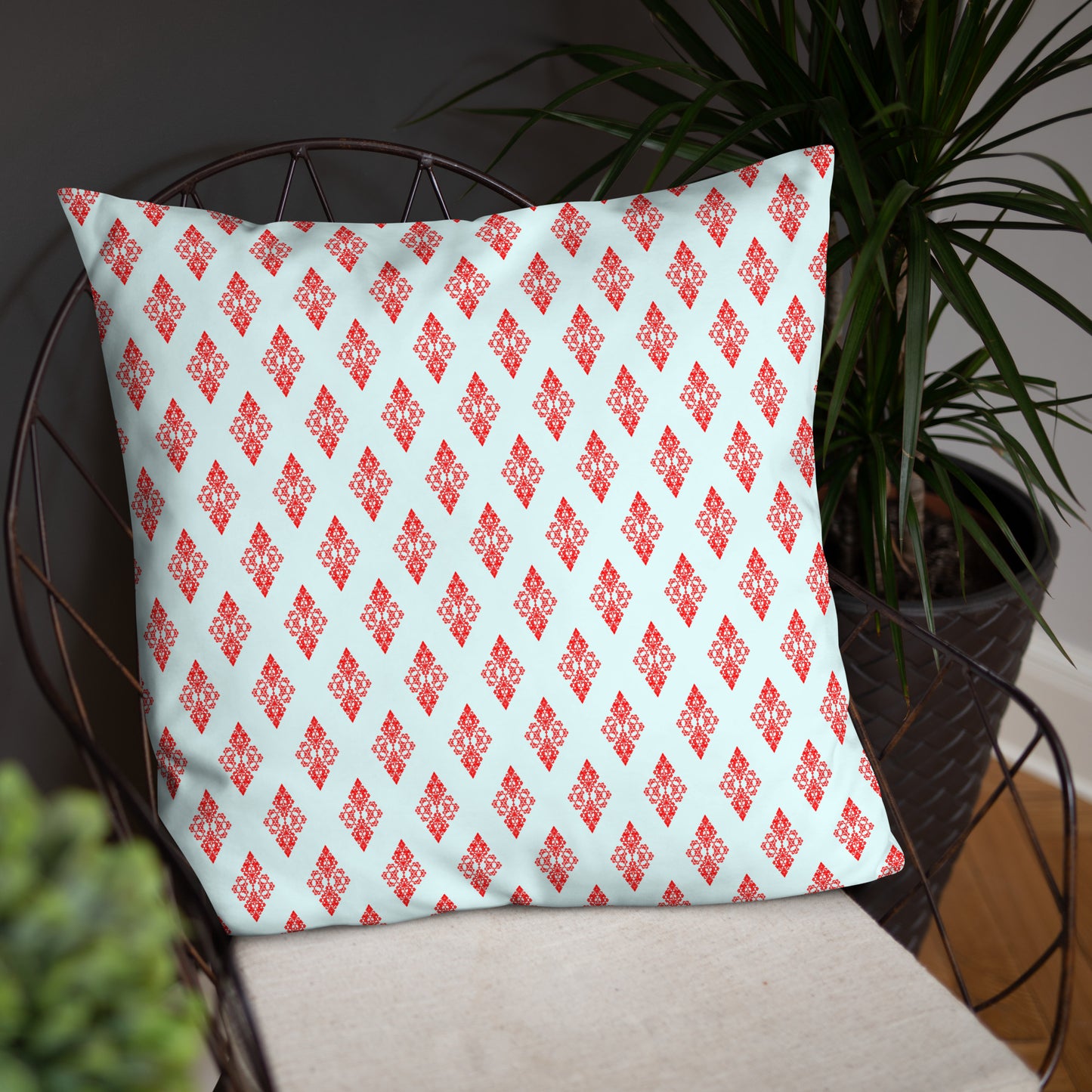 22″×22″ throw pillow with the 'Digon' sky blue and red geometric pattern on a chair.