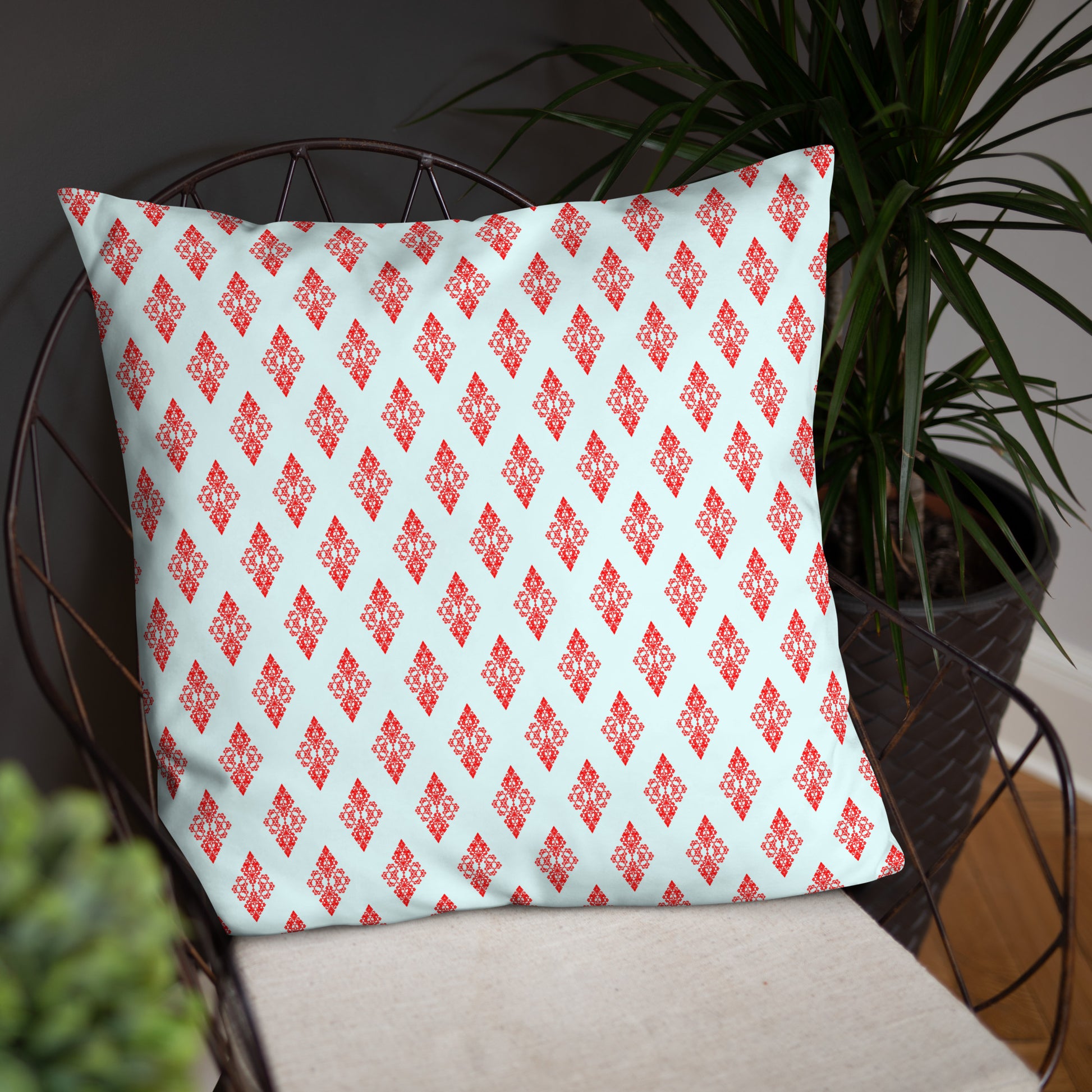 22″×22″ throw pillow with the 'Digon' sky blue and red geometric pattern on a chair.
