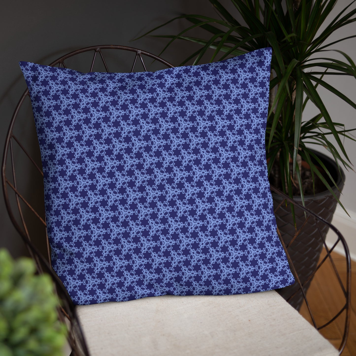 22″×22″ throw pillow with the 'Triagon' navy and blue geometric pattern on a chair.