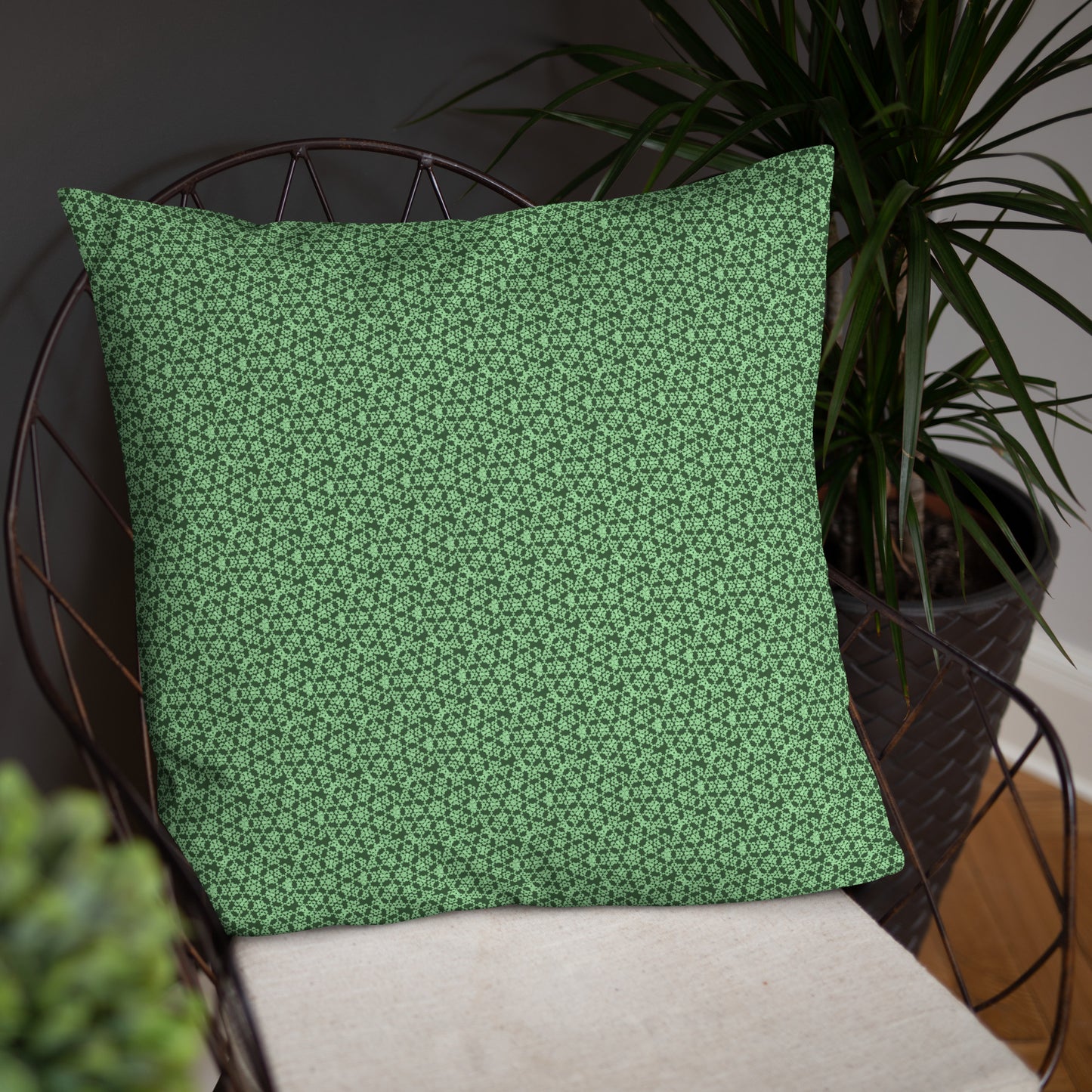 22″×22″ throw pillow with the 'Heptagon' green geometric pattern on a chair.