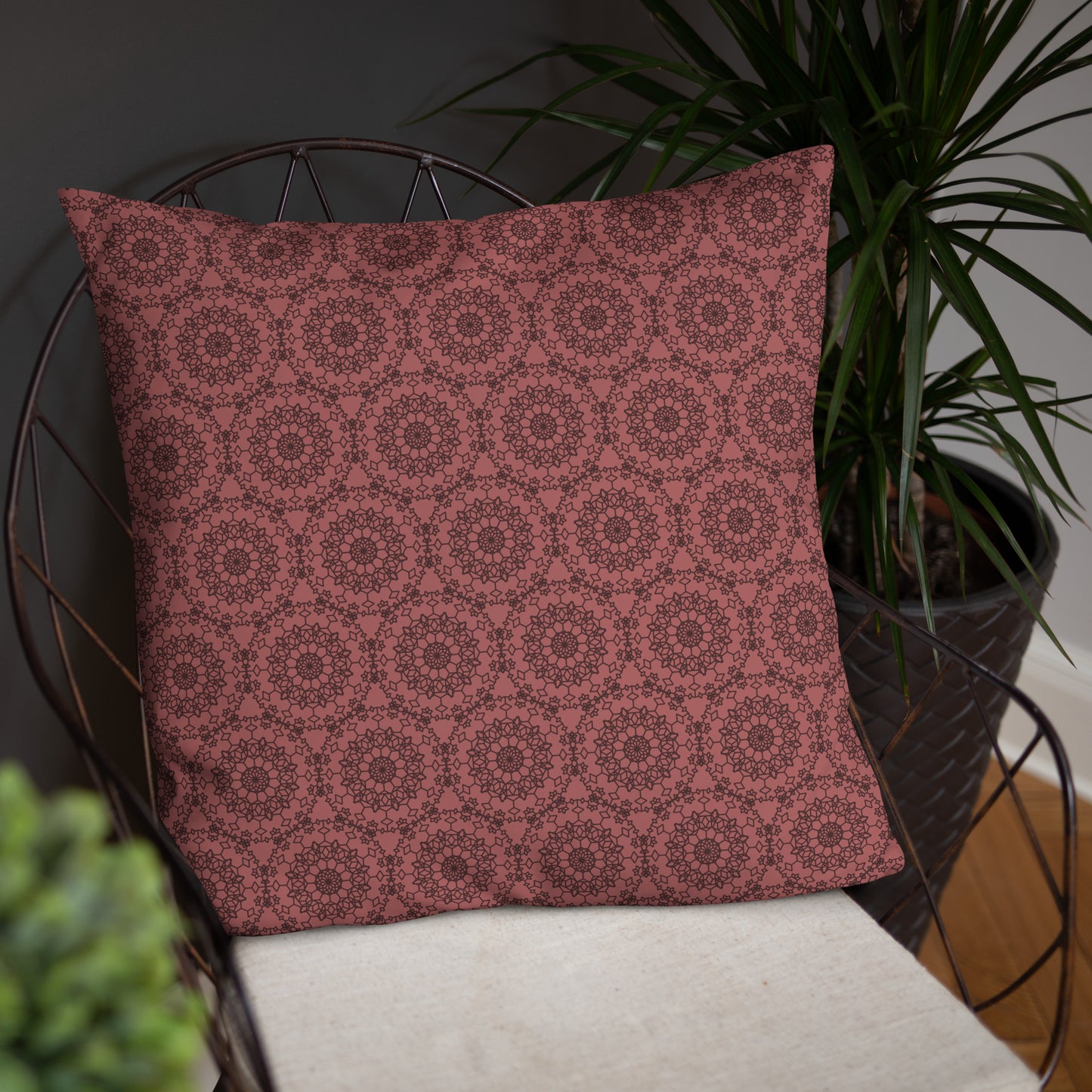 22″×22″ throw pillow with the 'Dodecagon' rose geometric pattern on wire chair with white cushion.