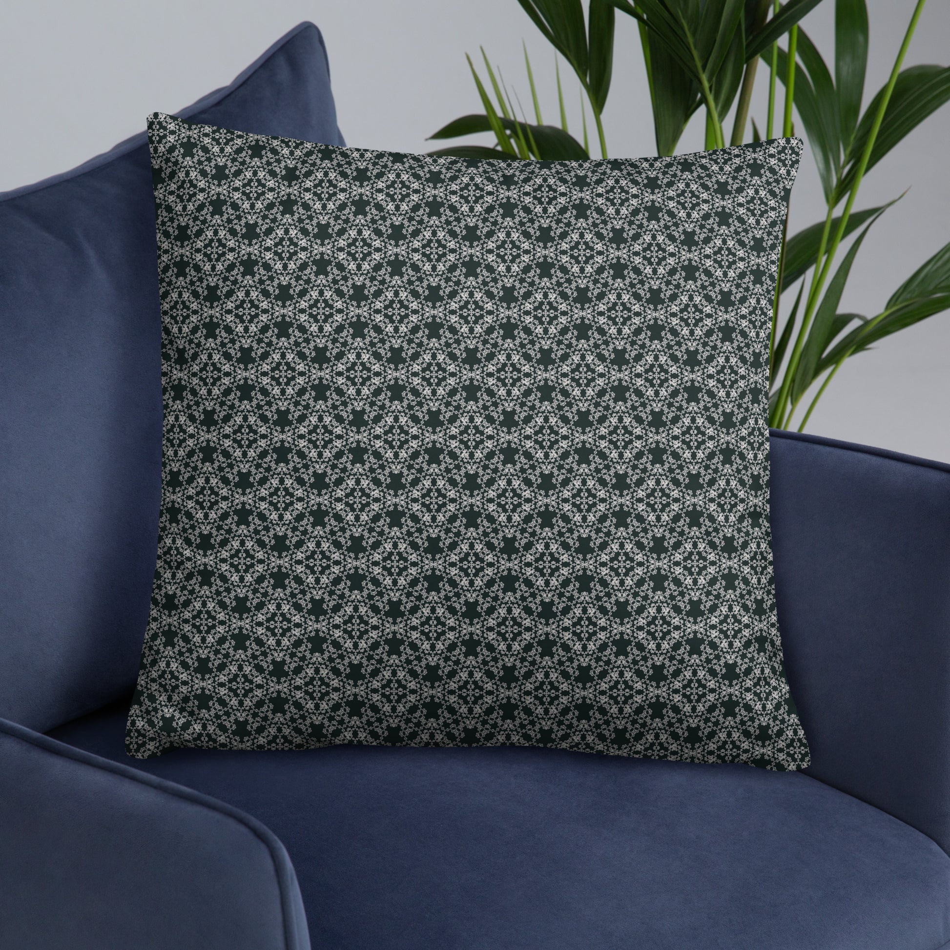 Front of the 22″×22″ basic pillow with the 'Quadragon' charcoal and white fractal geometric pattern on an armchair.