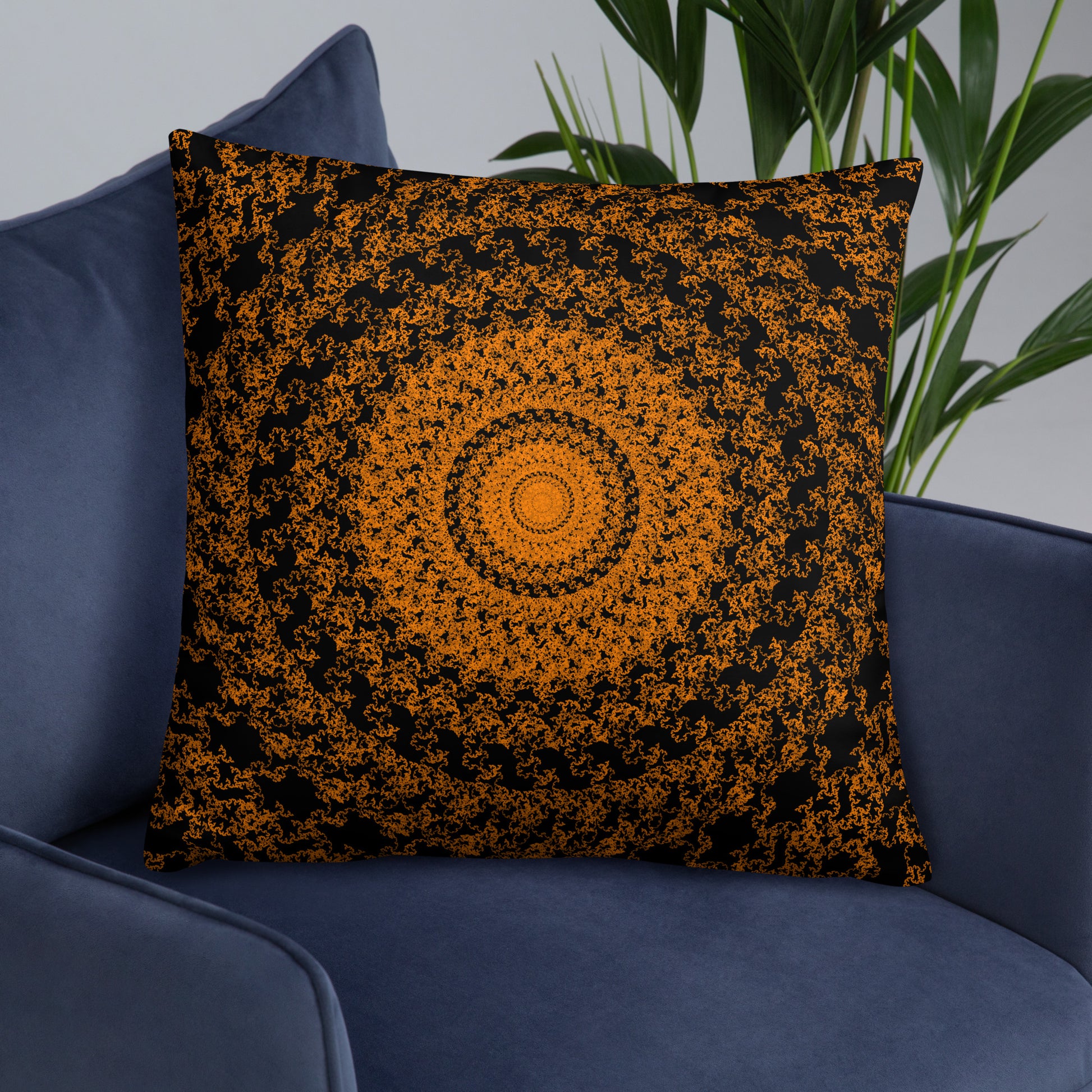 22″×22″ throw pillow with the 'The Sun' orange and black geometric design on an armchair.