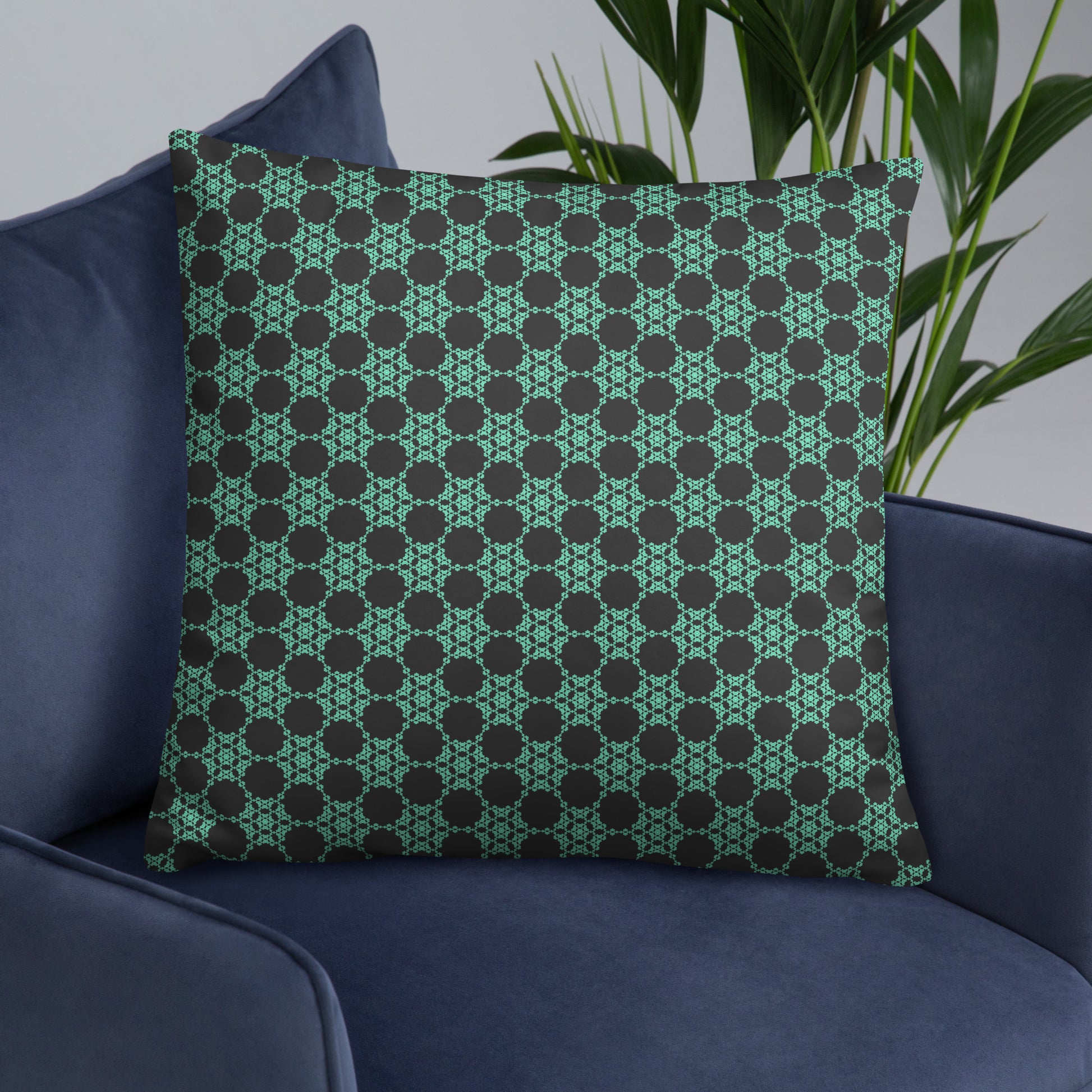 22″×22″ throw pillow with the 'Flowers Victory' charcoal and mint geometric pattern on an armchair.