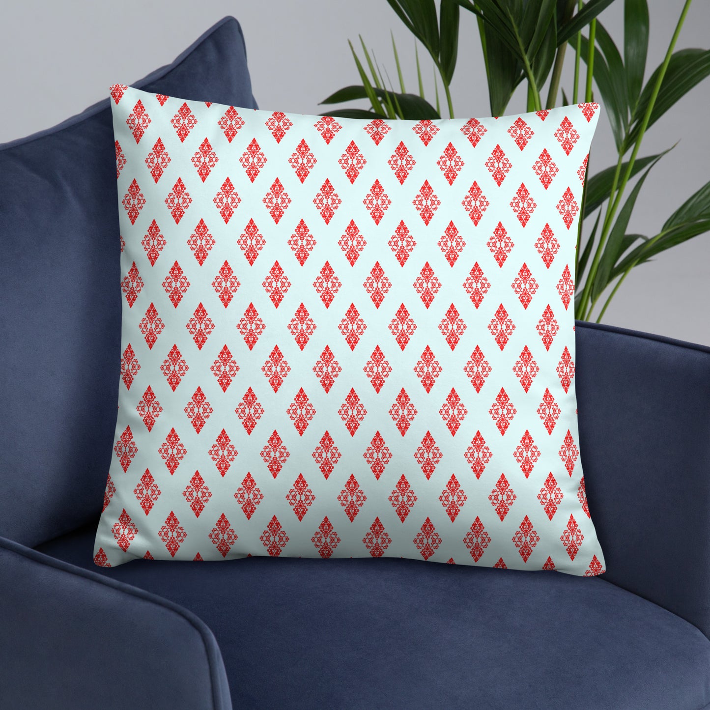 22″×22″ throw pillow with the 'Digon' sky blue and red geometric pattern on an armchair.