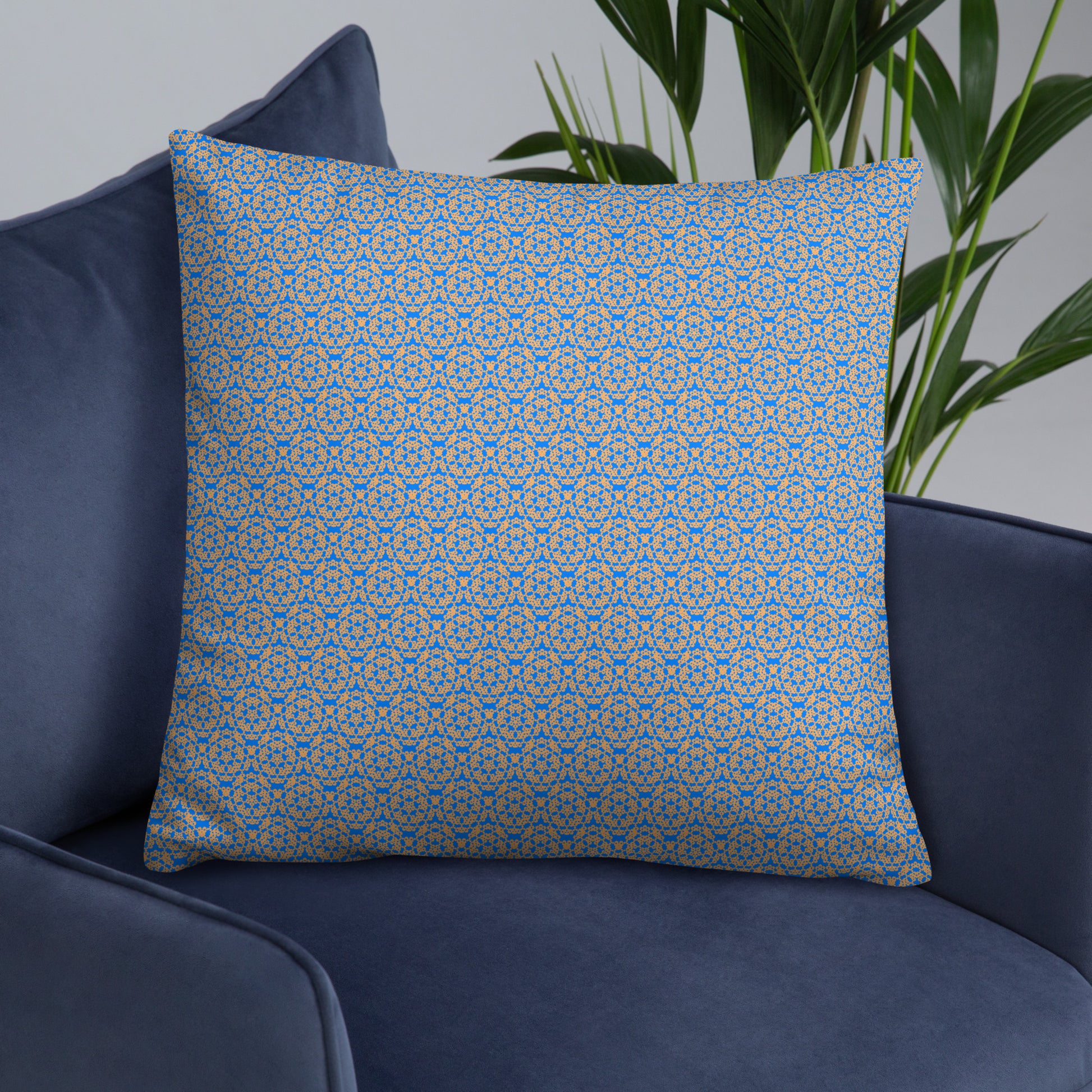 22″×22″ throw pillow with the 'Pentagon' blue and yellow geometric pattern on an armchair.