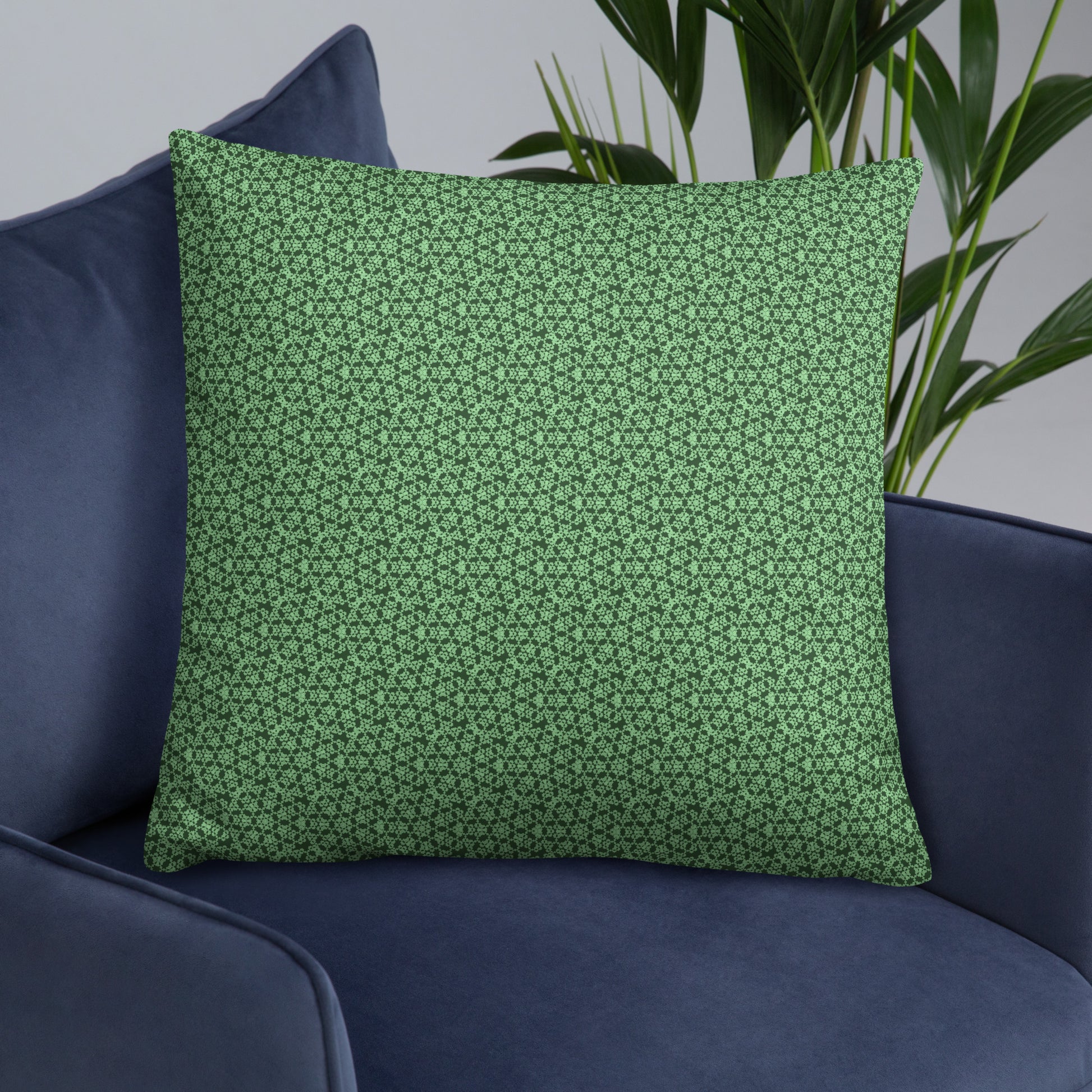 22″×22″ throw pillow with the 'Heptagon' green geometric pattern on an armchair.