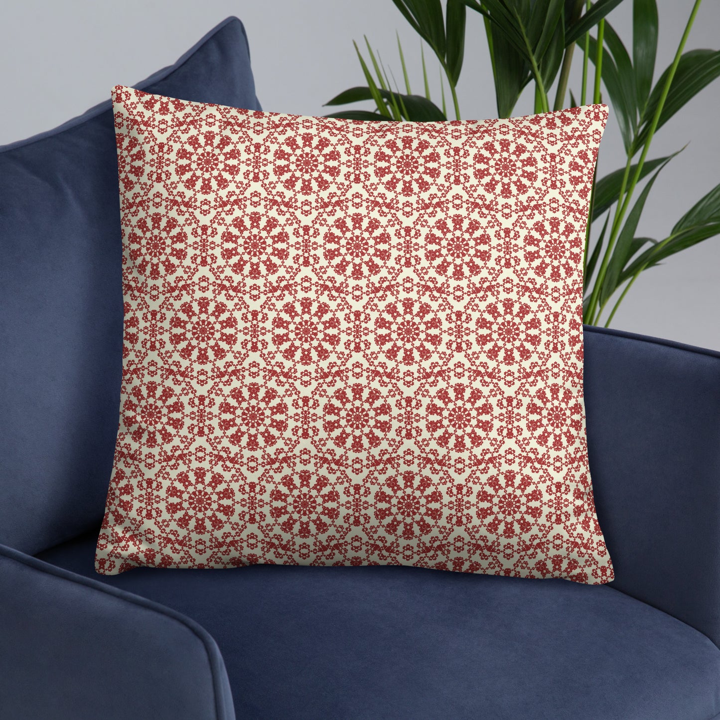 22″×22″ throw pillow with the ‘Decagon’ terracotta and beige geometric pattern on a navy blue armchair.
