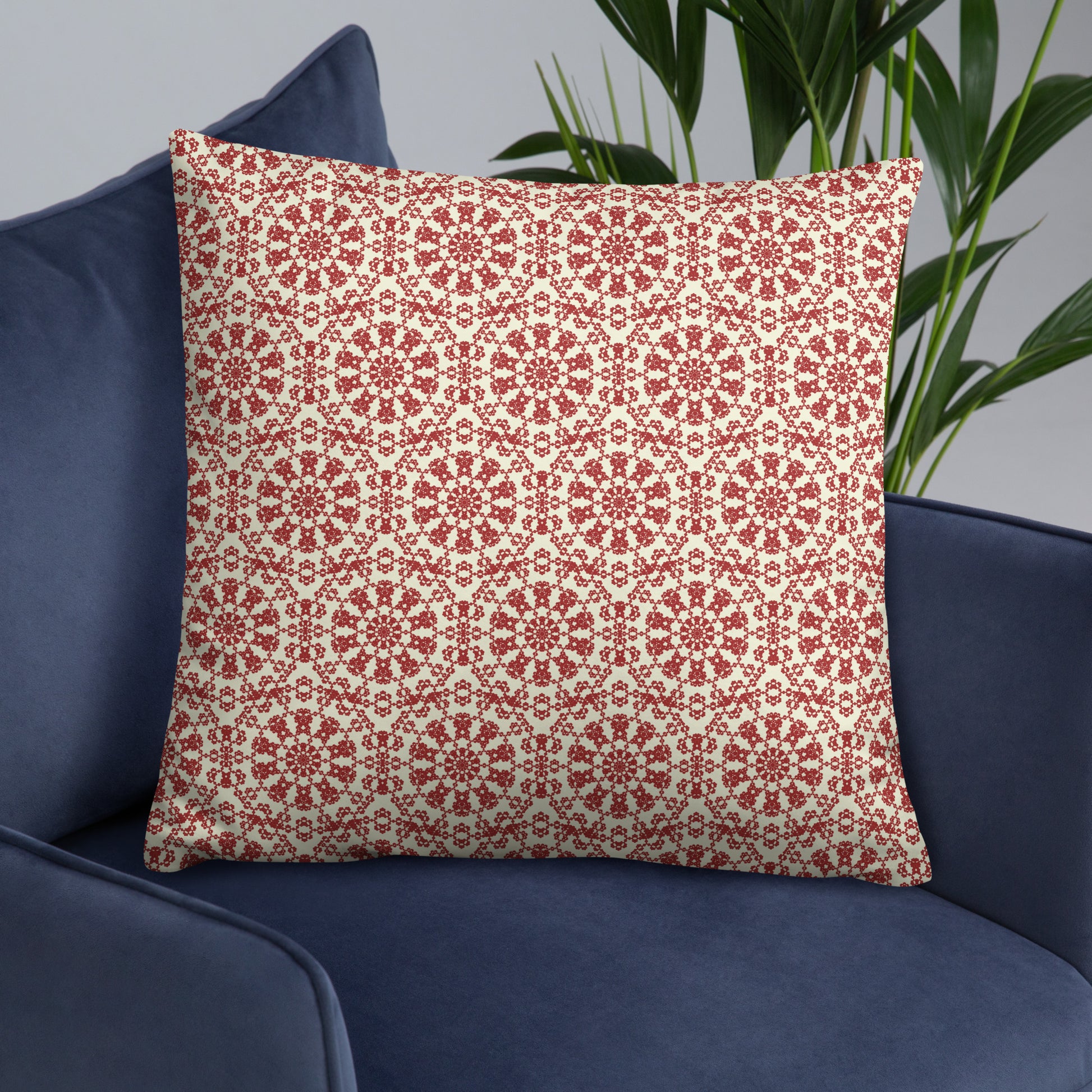 22″×22″ throw pillow with the ‘Decagon’ terracotta and beige geometric pattern on a navy blue armchair.
