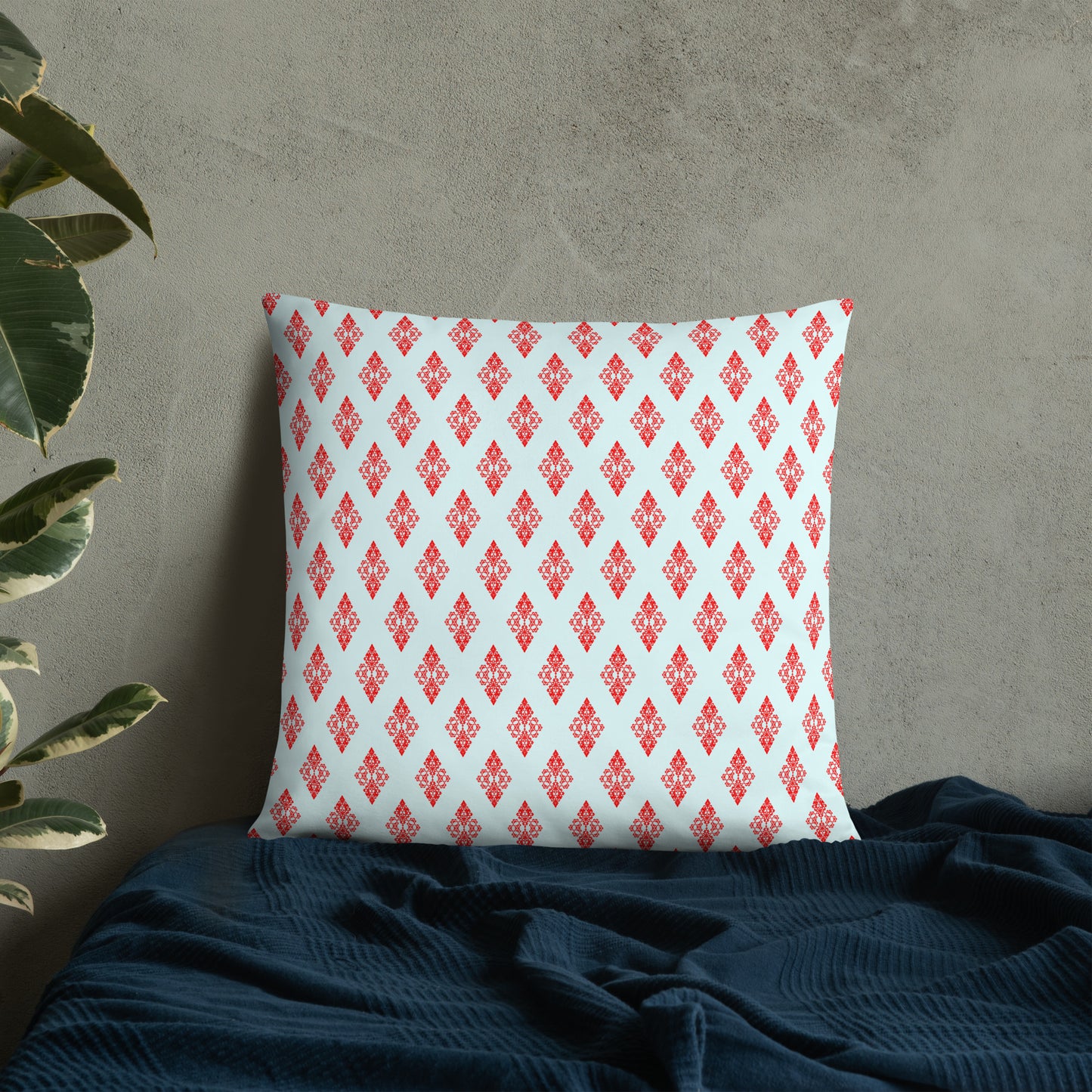 22″×22″ throw pillow with the 'Digon' sky blue and red geometric pattern on a bed.