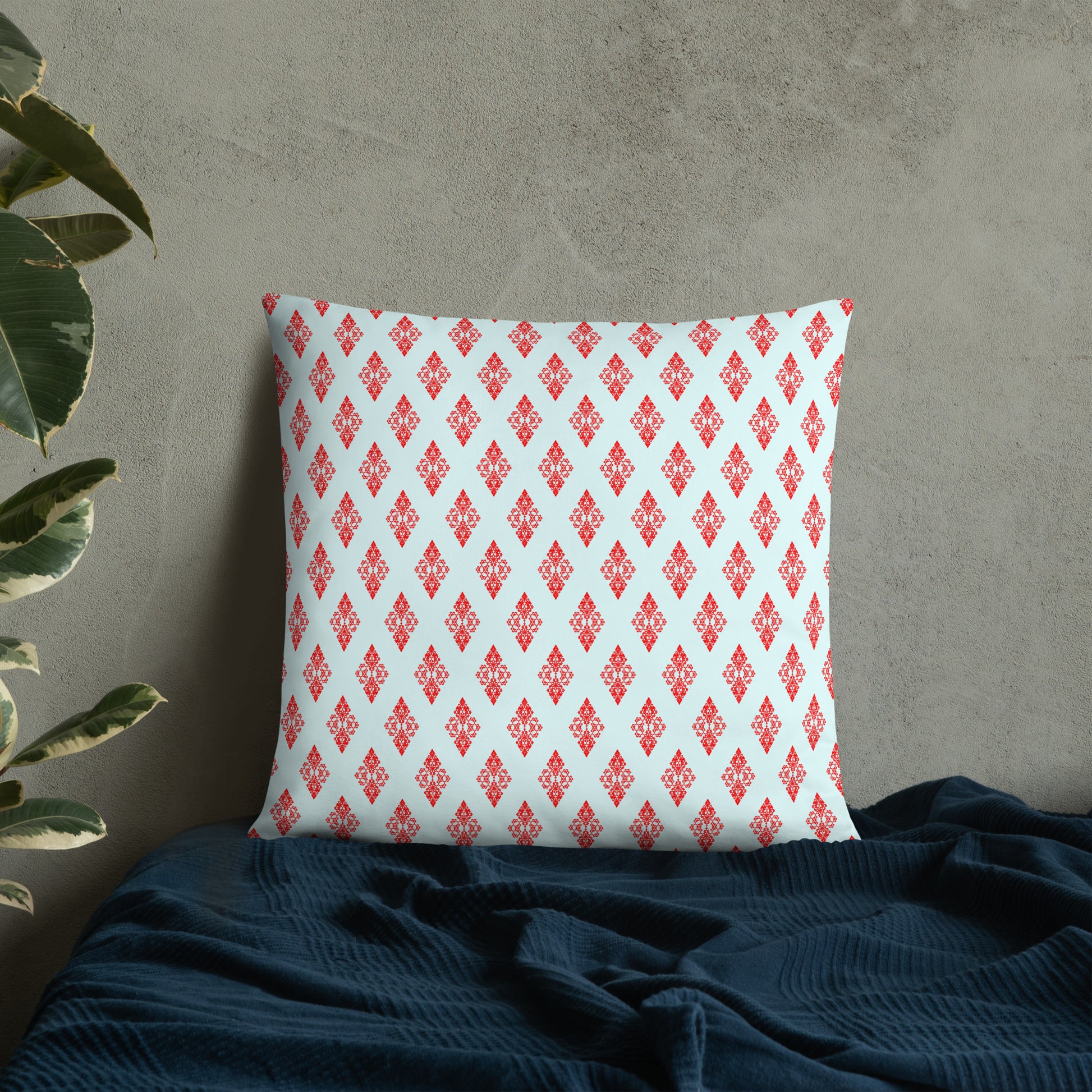 22″×22″ throw pillow with the 'Digon' sky blue and red geometric pattern on a bed.