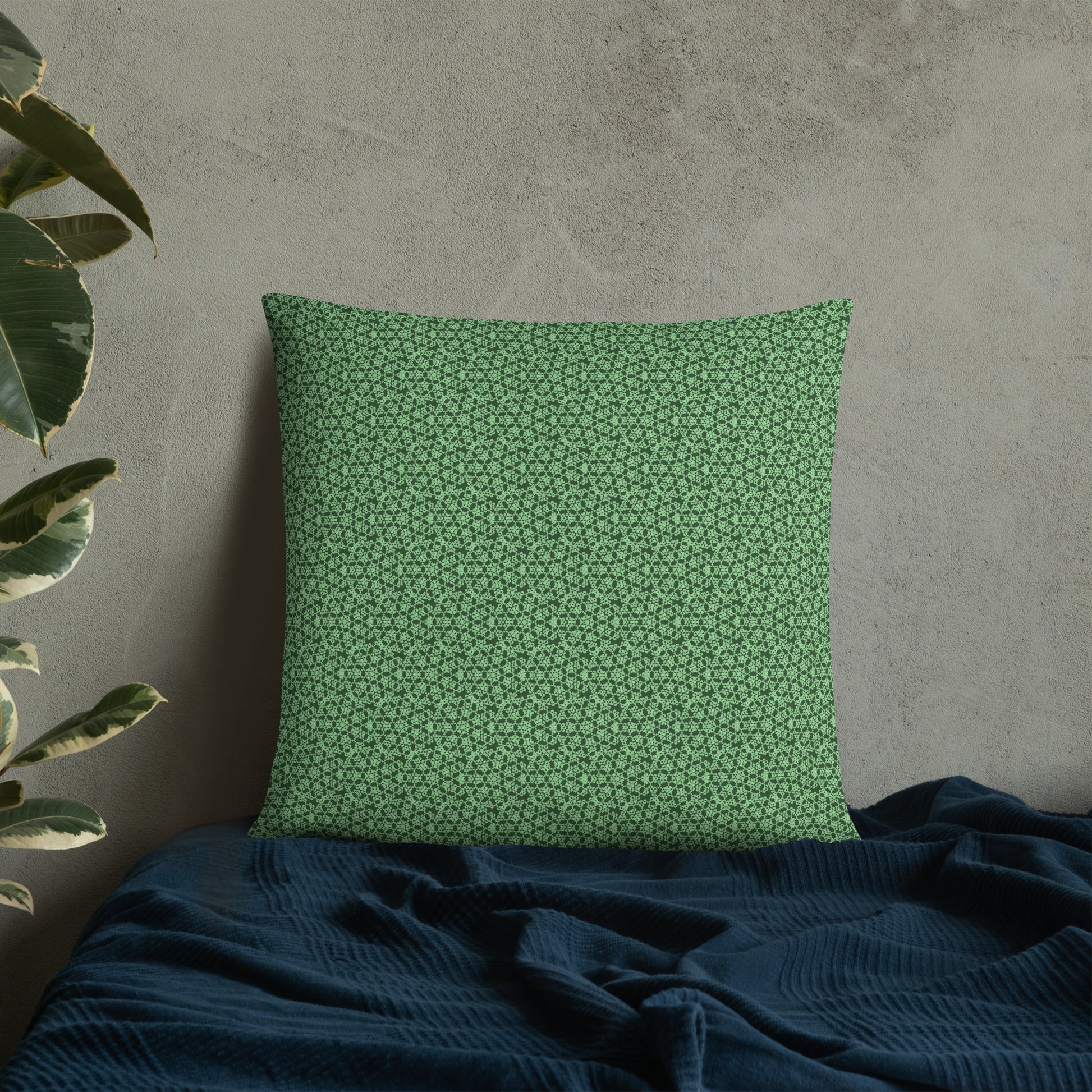 22″×22″ throw pillow with the 'Heptagon' green geometric pattern on a bed.