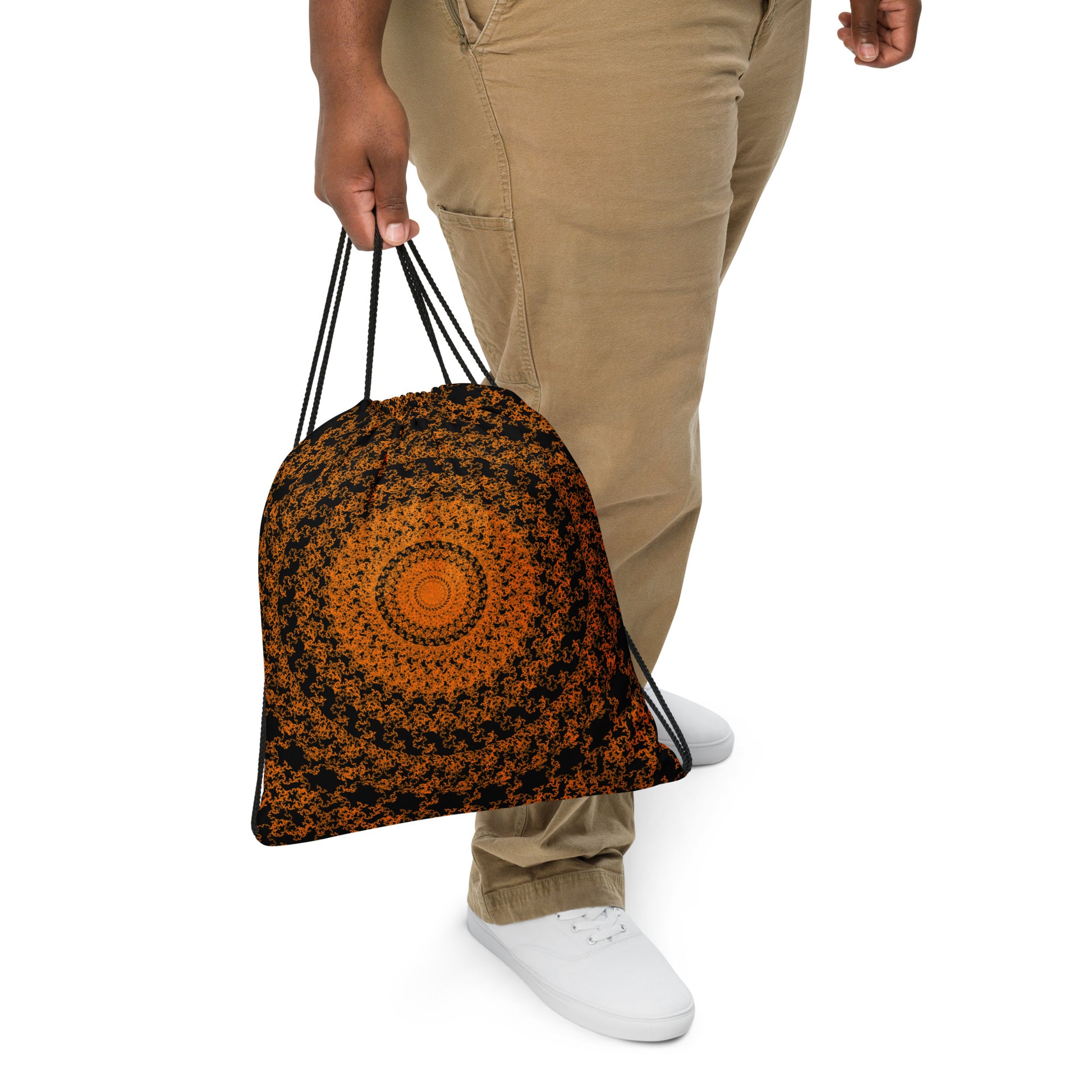 Close up of a person slinging the drawstring bag with the 'The Sun' black and orange fractal design.