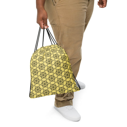 Close up of a person slinging the drawstring bag with the 'Hexagon' yellow and black fractal geometric design.