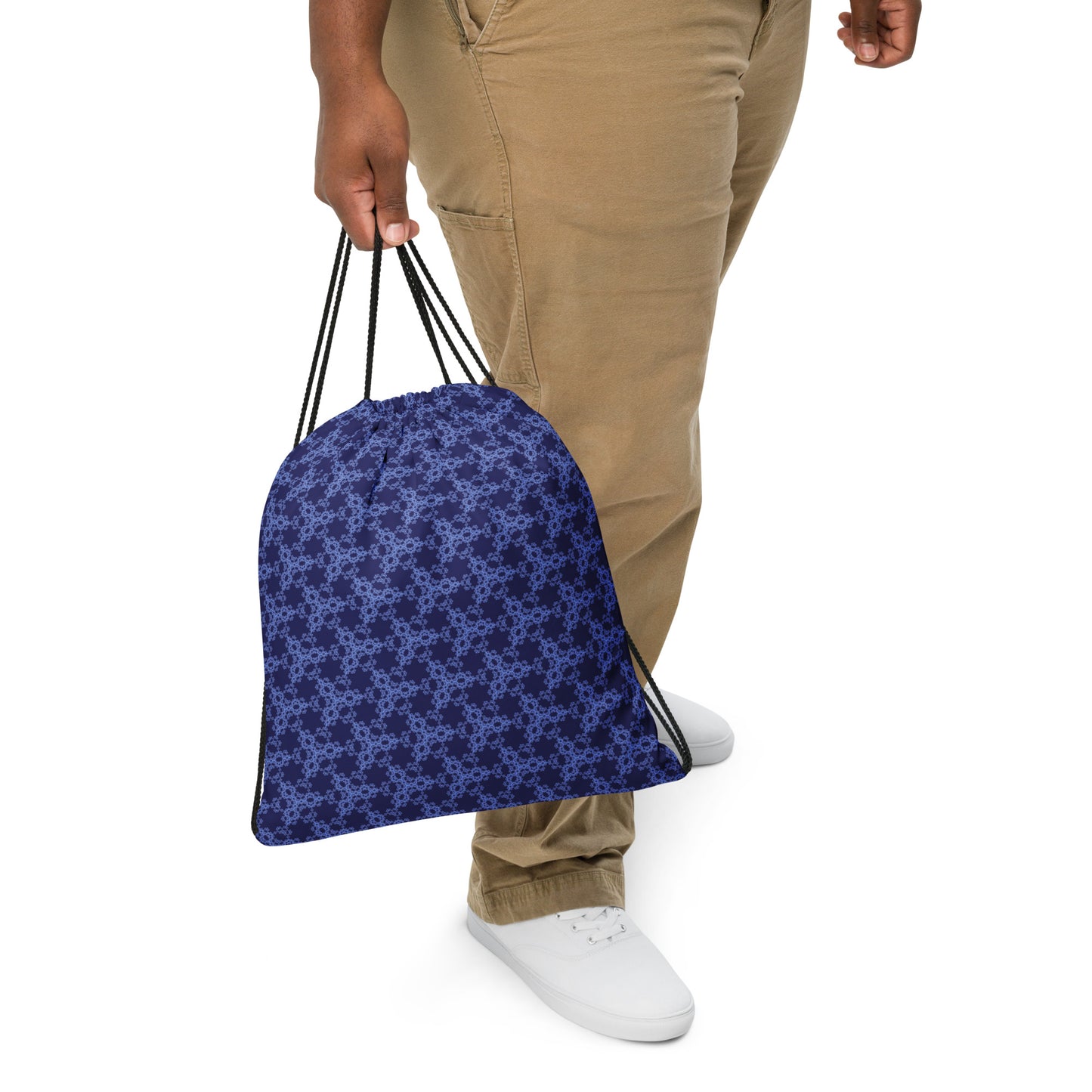 Close up of a person slinging the drawstring bag with the 'Triagon' navy and blue fractal geometric design.