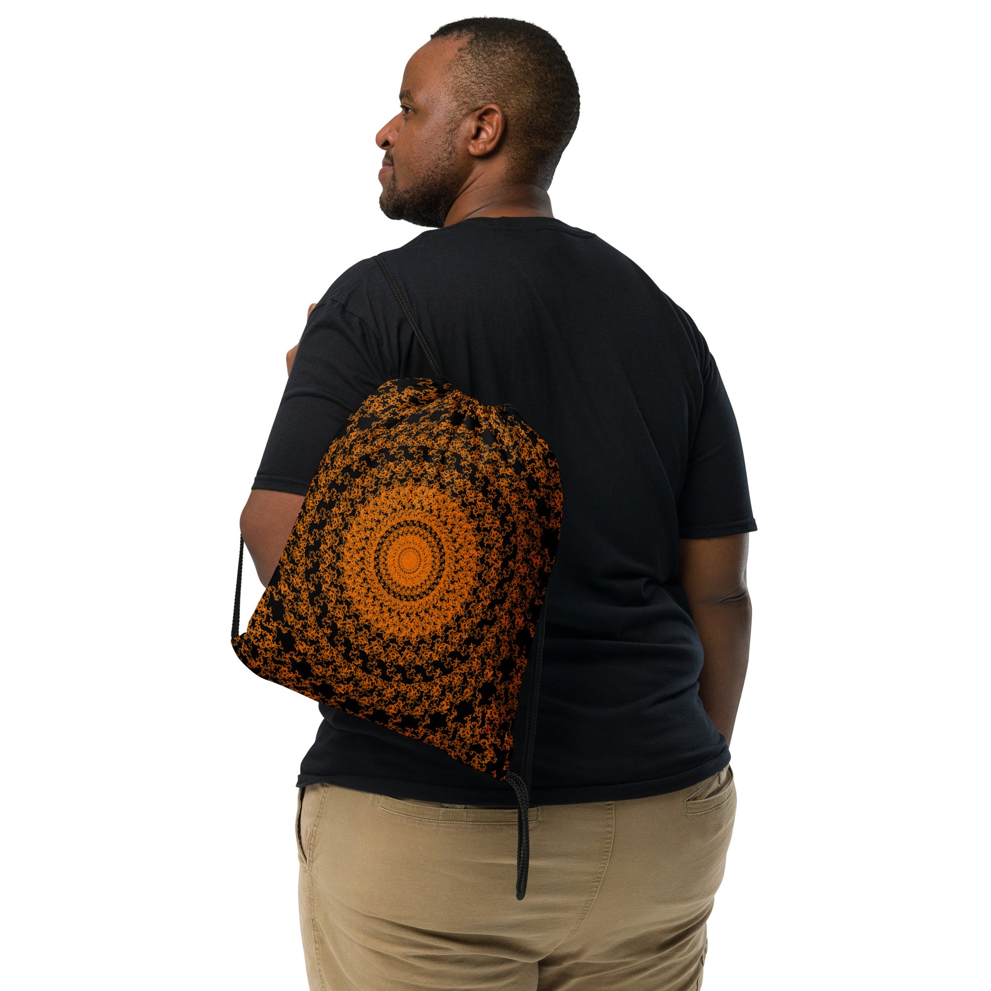 Back shot of the drawstring bag with the 'The Sun' black and orange fractal design slung over a man's shoulder.