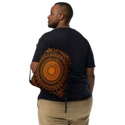 Back shot of the drawstring bag with the 'The Sun' black and orange fractal design slung over a man's shoulder.