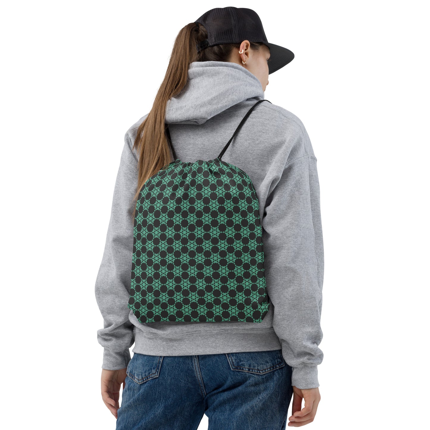 Back shot of a young woman wearing the drawstring bag with the 'Flowers Victory' dark grey and green fractal geometric pattern.
